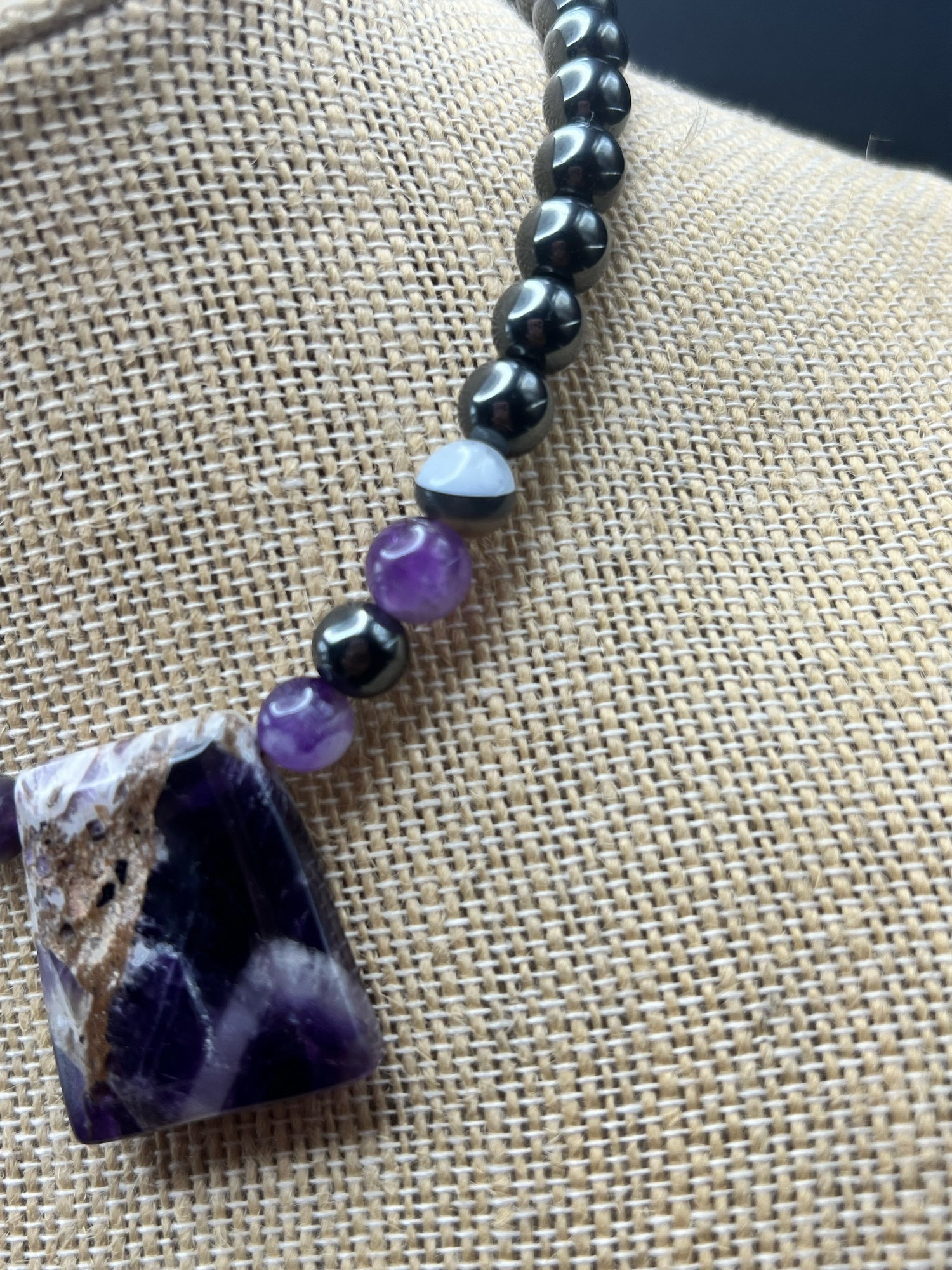 A close up of the light purple amethyst, silver grey hematite and banded opaque black agate