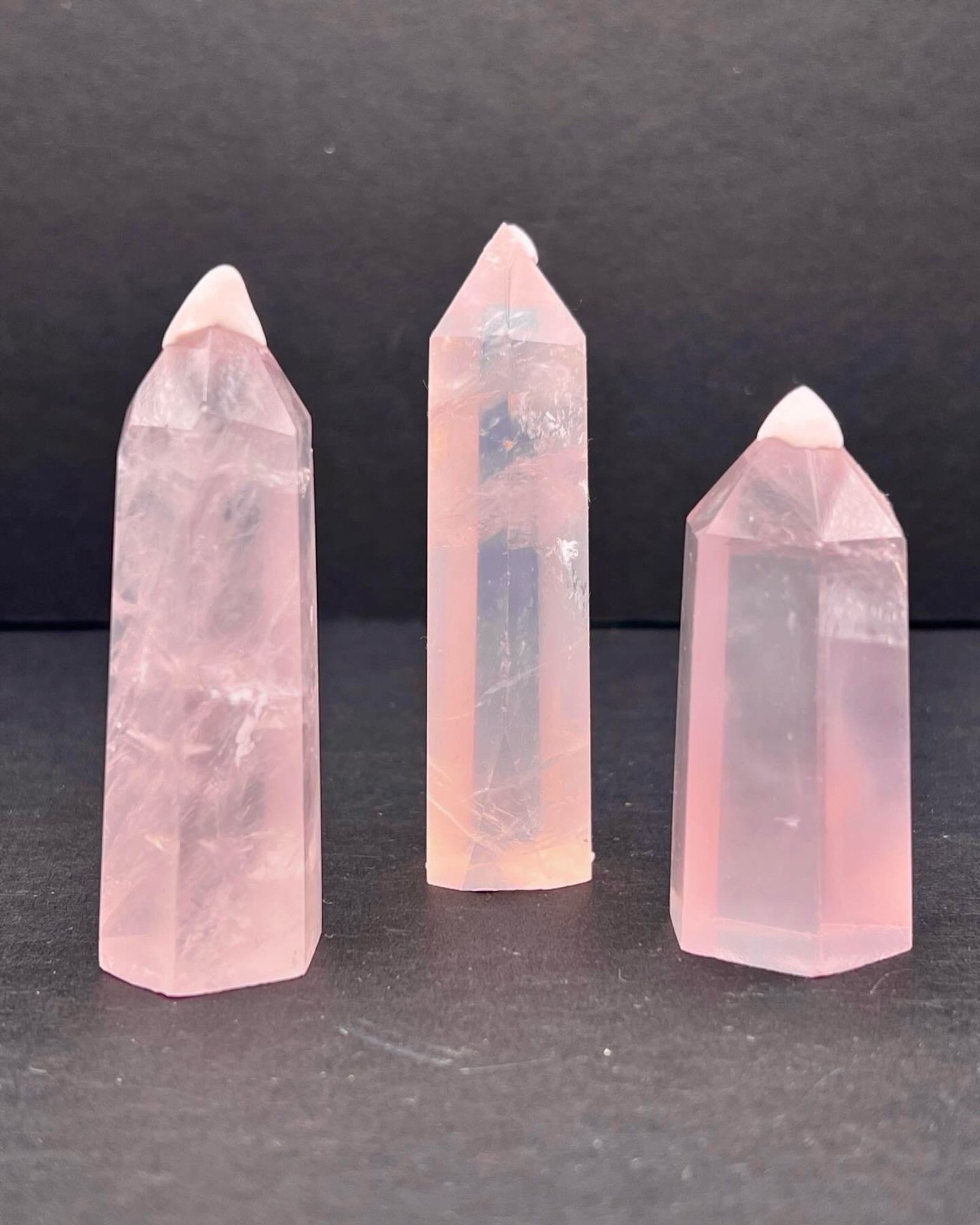 3 pink rose Quartz tower in front of a black background