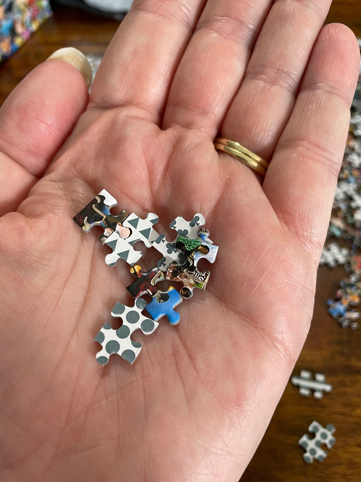 A handful of puzzle pieces showing how small they are (about the size of an adult fingernail)