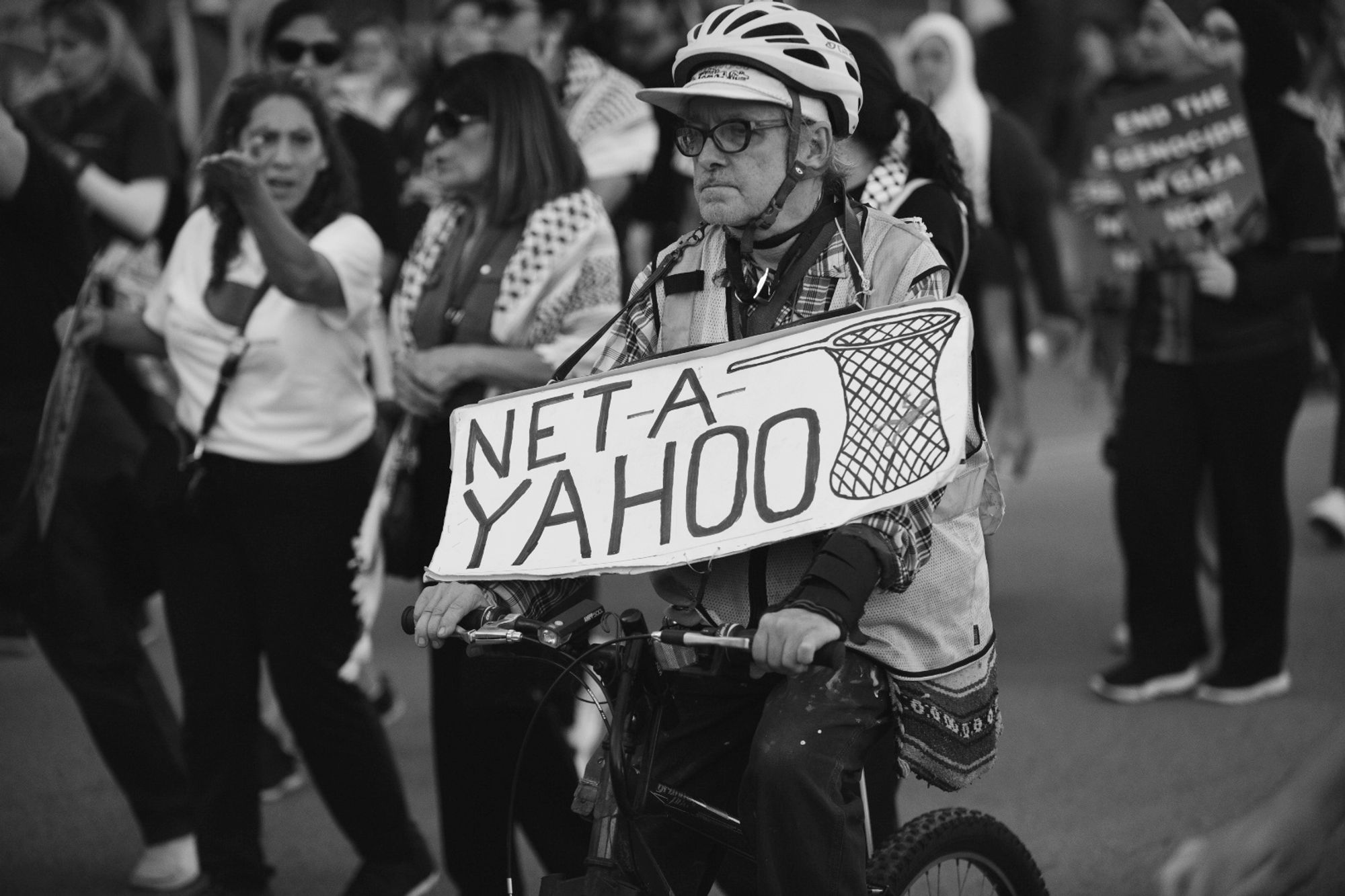 Protester on small bicycle with sign with image of net and it says NET A YAHOO