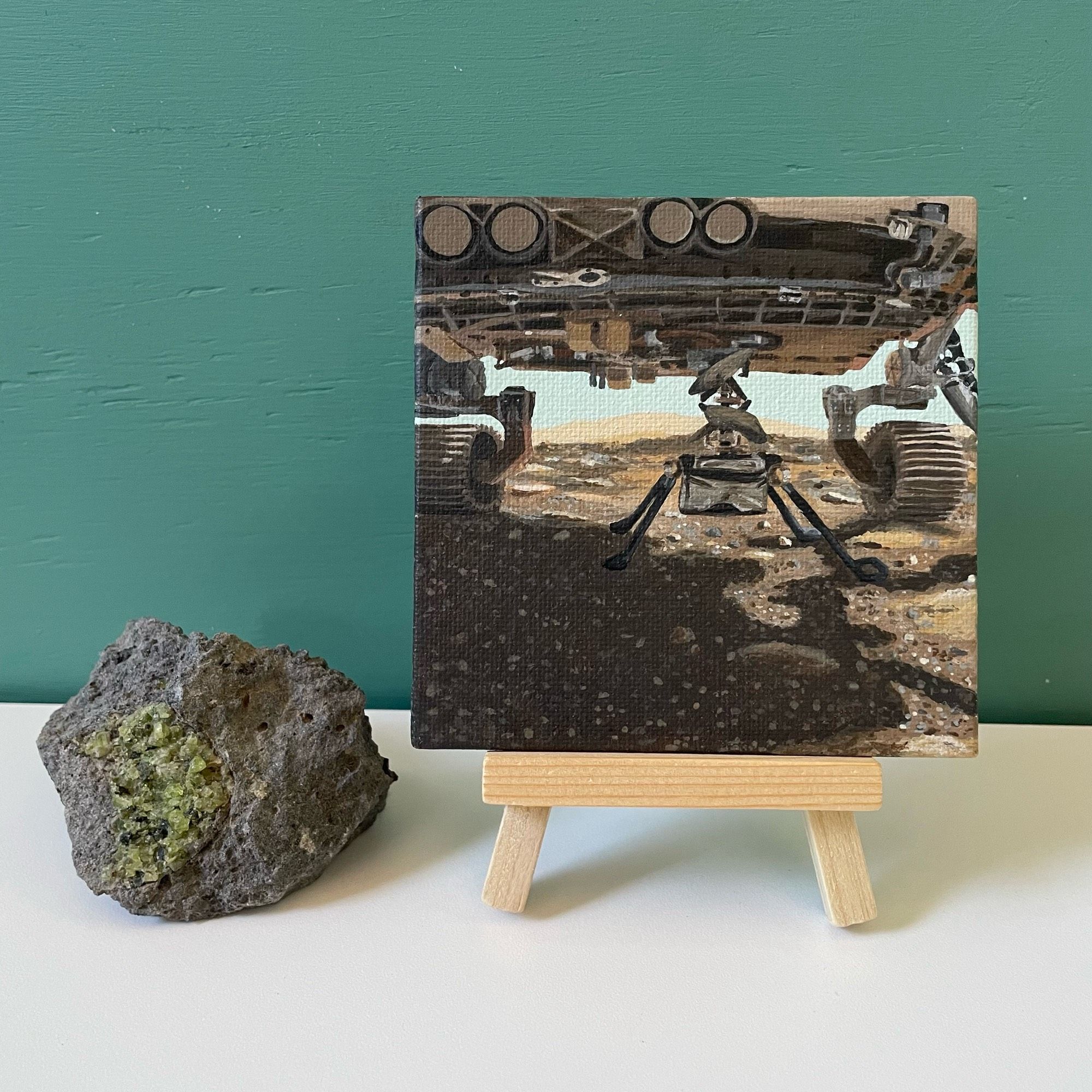 Mini painting of ingenuity and Percy on easel next to xenolith