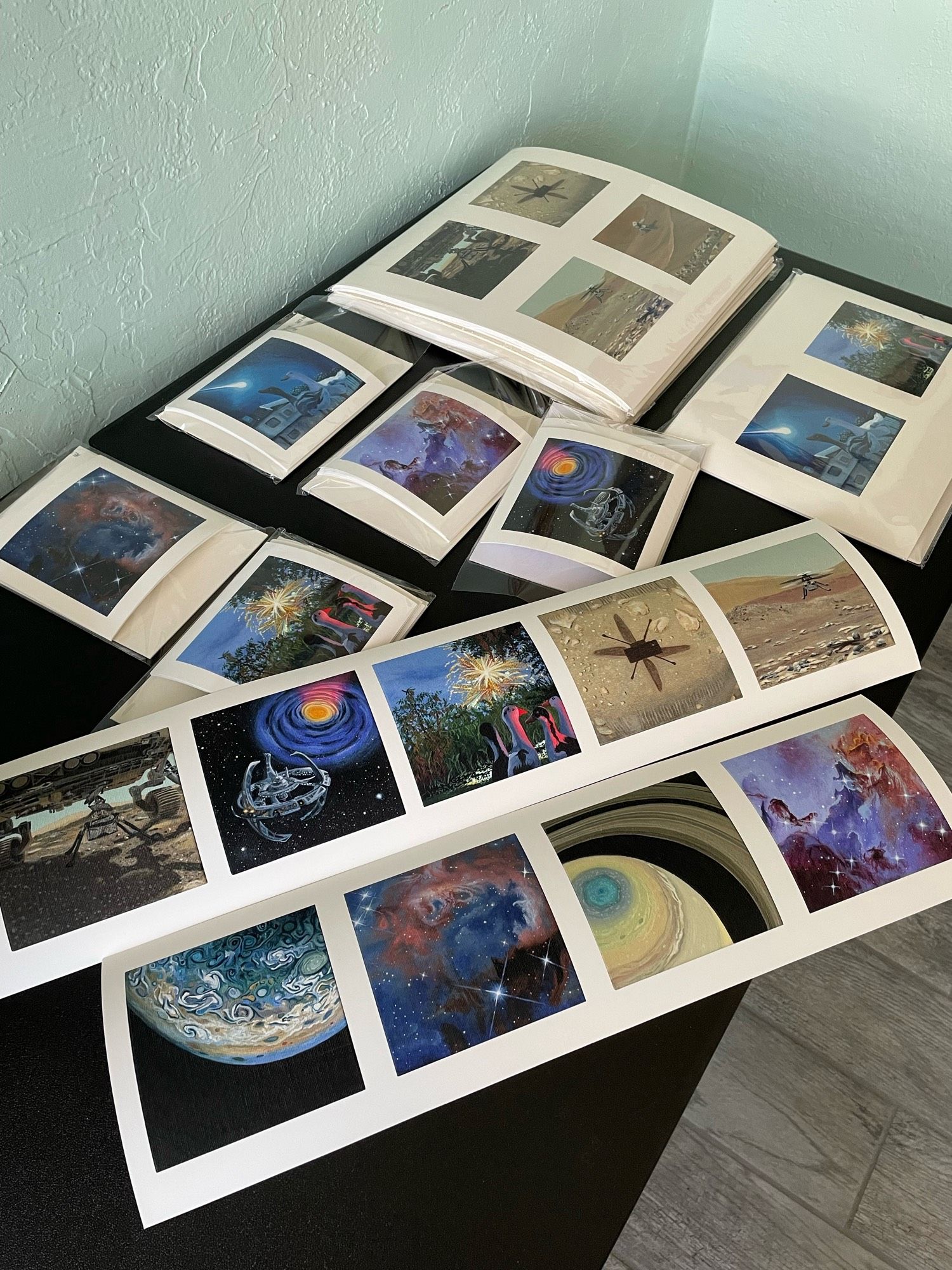 Table filled with prints of my mini paintings