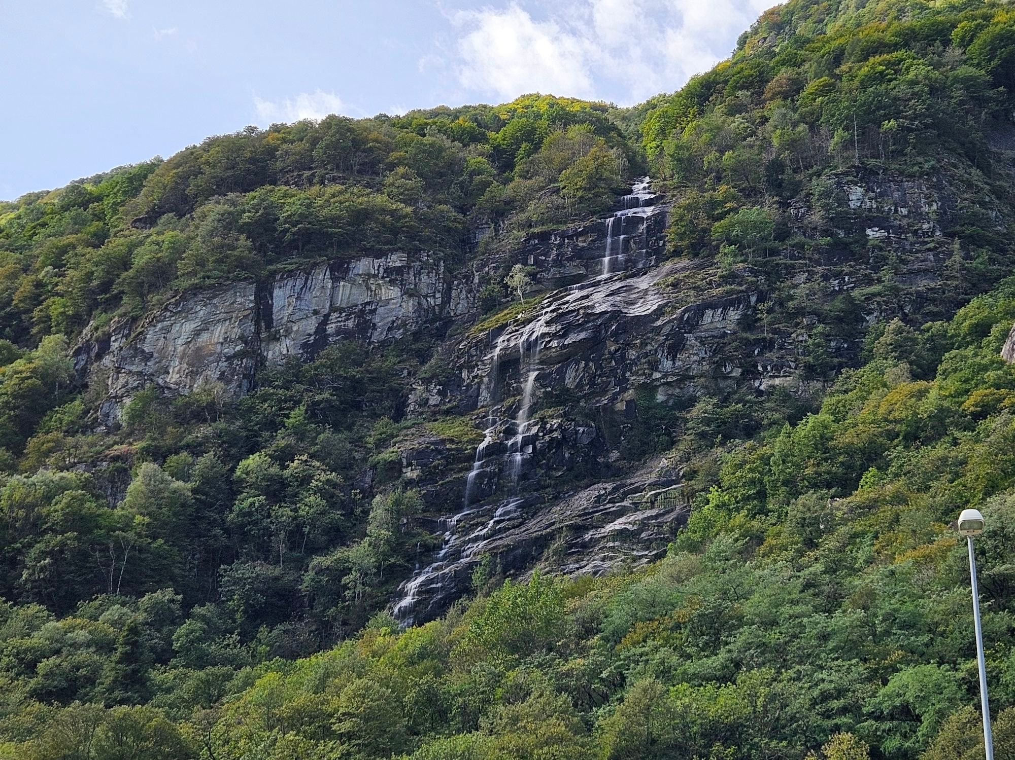 Bild zeigt einen weiteren Wasserfall, der einen Hsng hinab fließt.