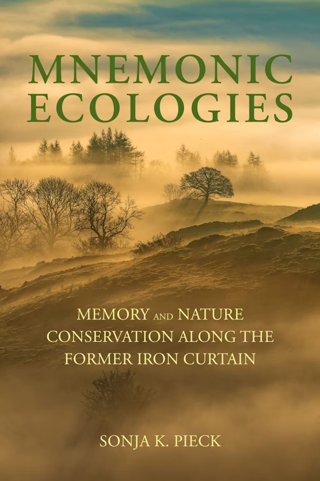 Cover of Mnemonic ecologies with rolling hills with sparse trees in fog.