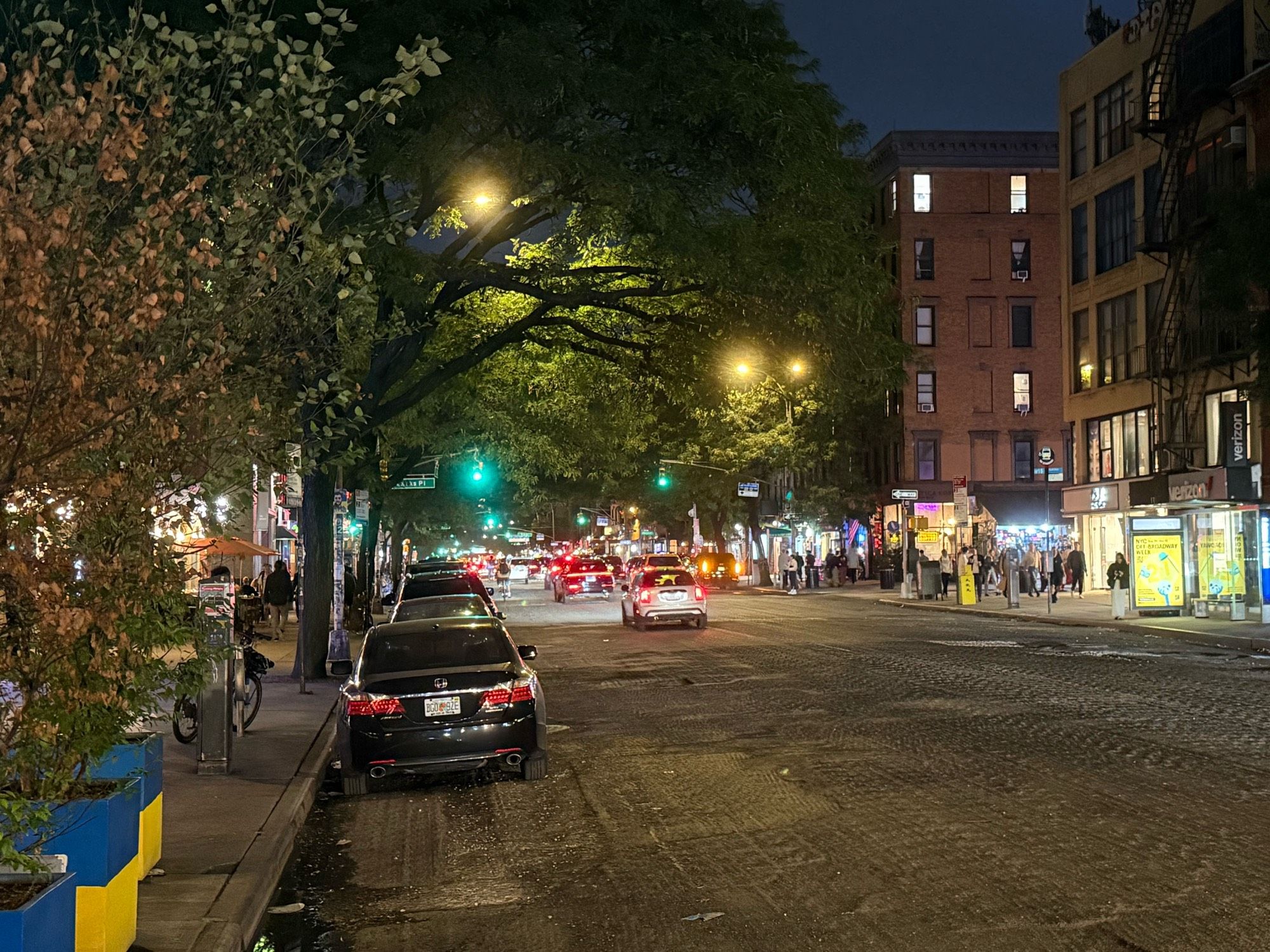 Cars parked along a curb where a protected bike lane was erased after the street was milled