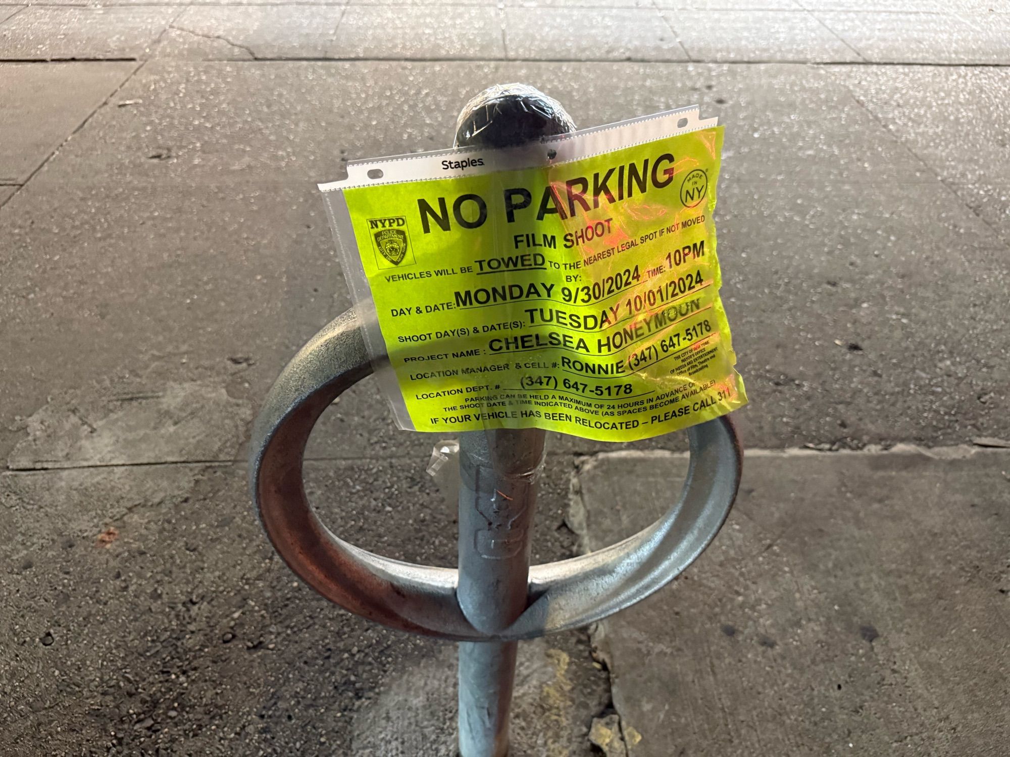 A temporary sign indicating the cones were placed to prevent parking on the site of a film shoot.