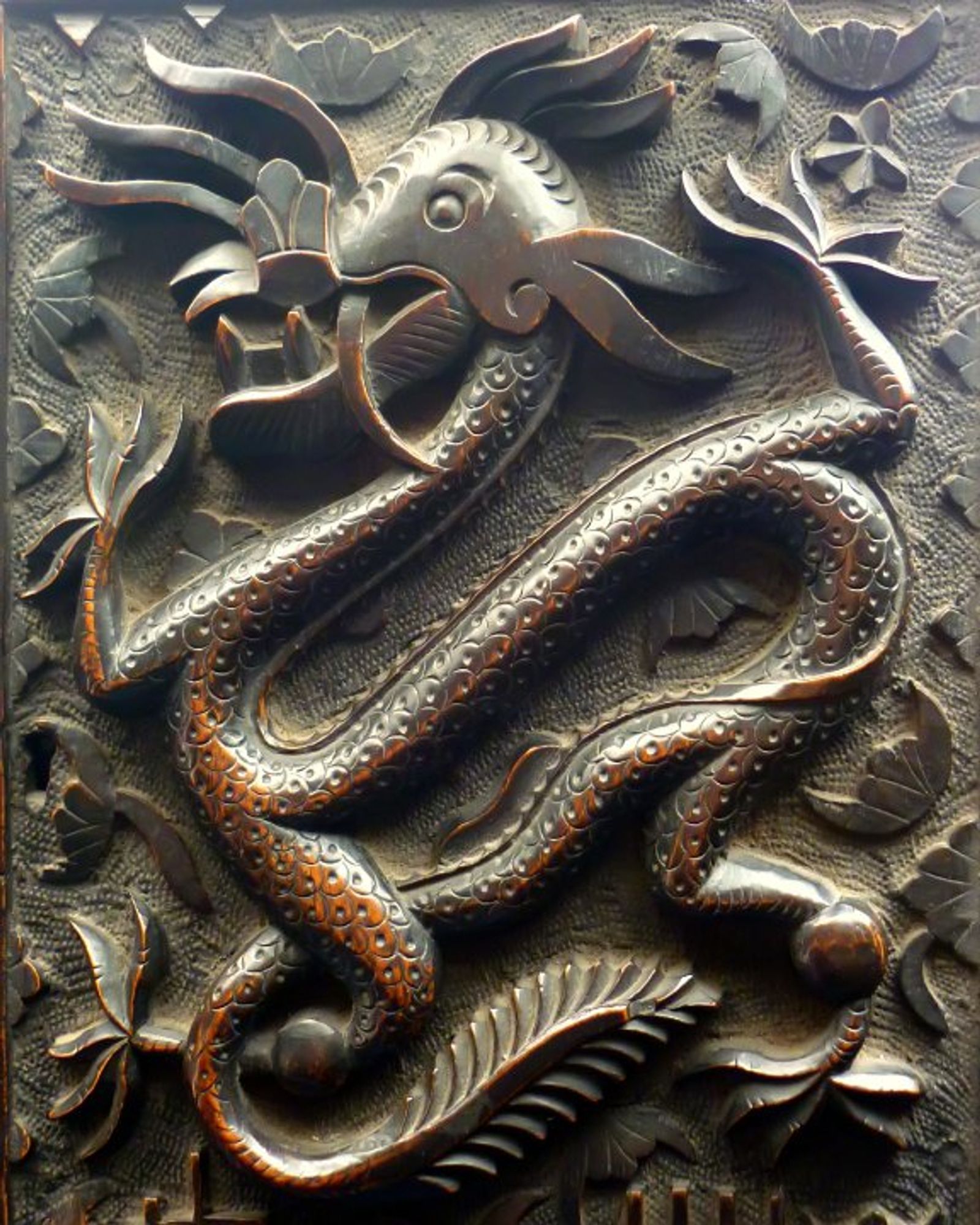 Carving of a dragon on an old wooden door