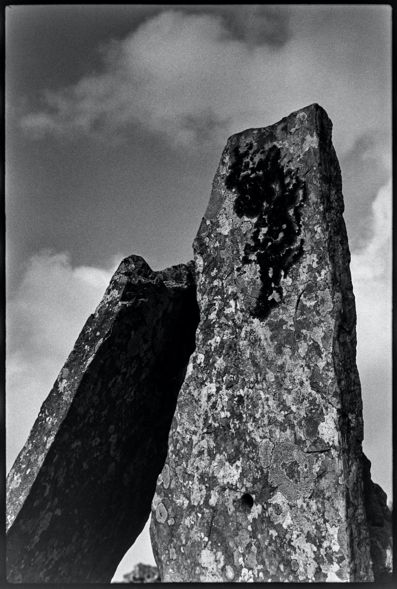 Two lichen-covered stones seen against the sky