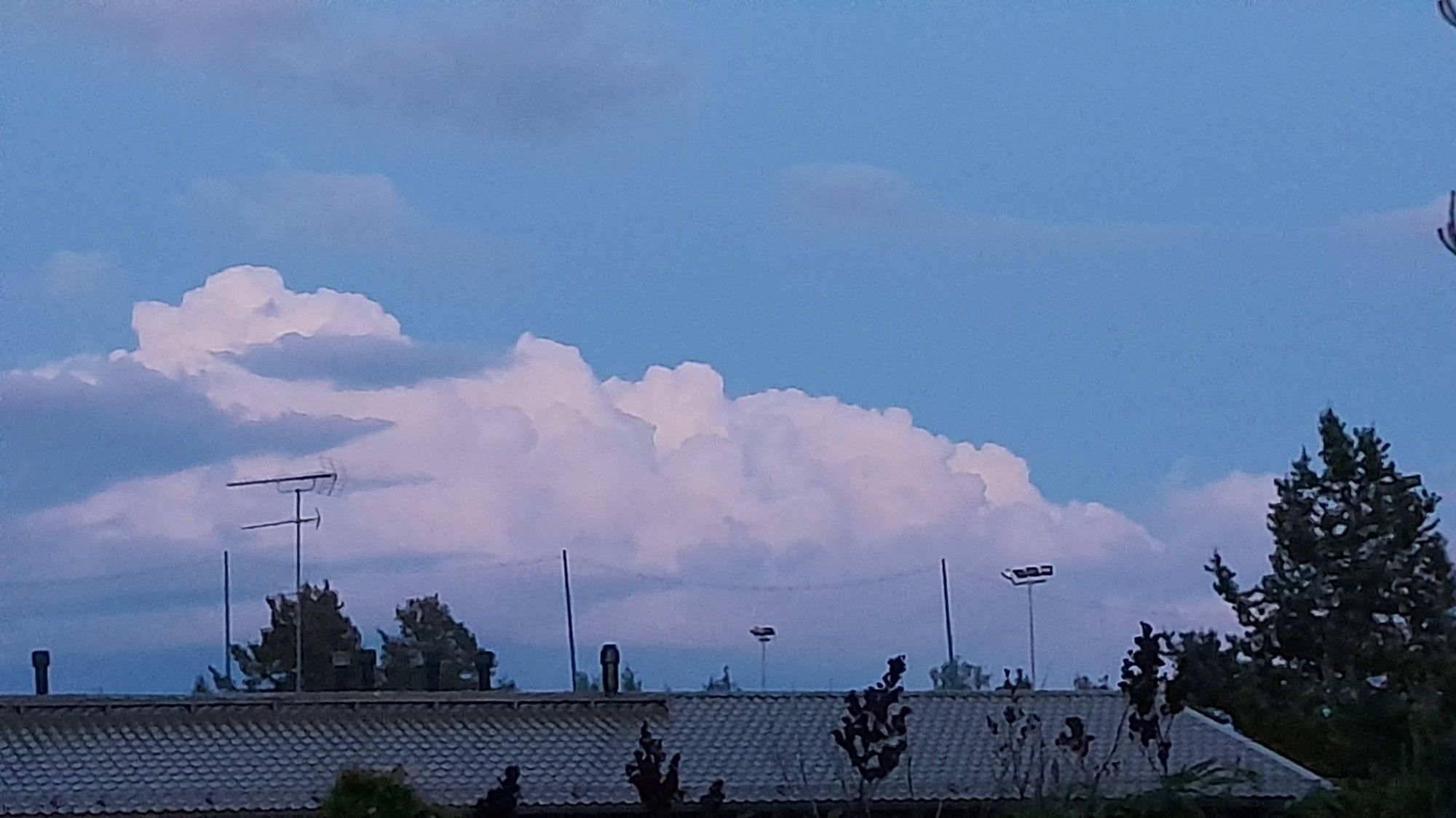 Shiny white clouds in low light skies, in distance.