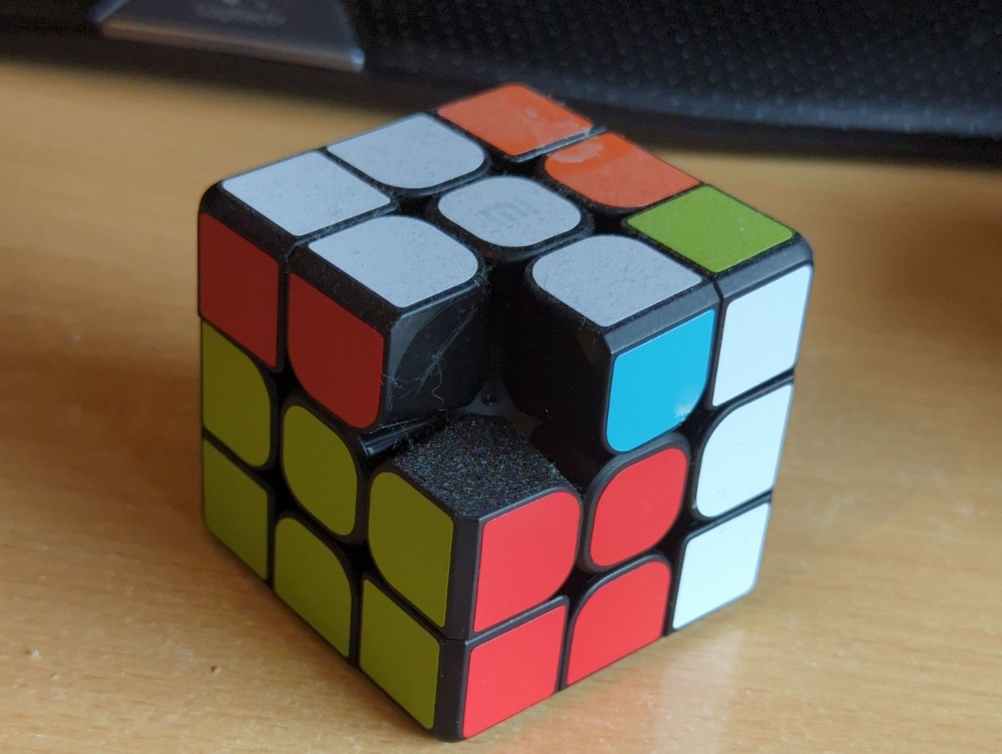 A very dusty Bluetooth Rubik's cube missing a corner