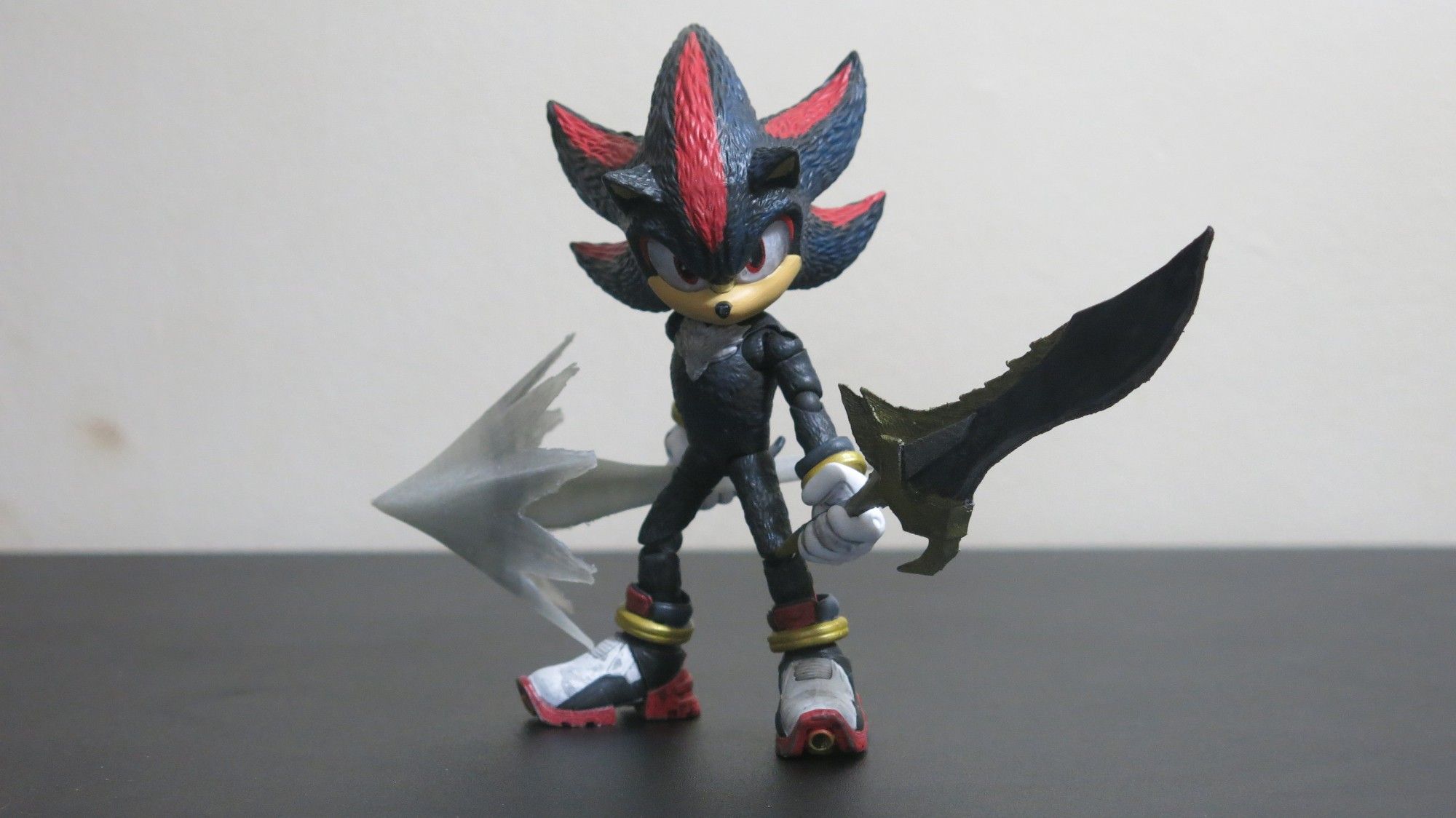 Shadow action figure from Sonic the Hedgehog 3, repainted to add depth to his fur colors and wear & tear to the shoes. He's holding a 3D printed Chaos Spear and Lancelot Sword.