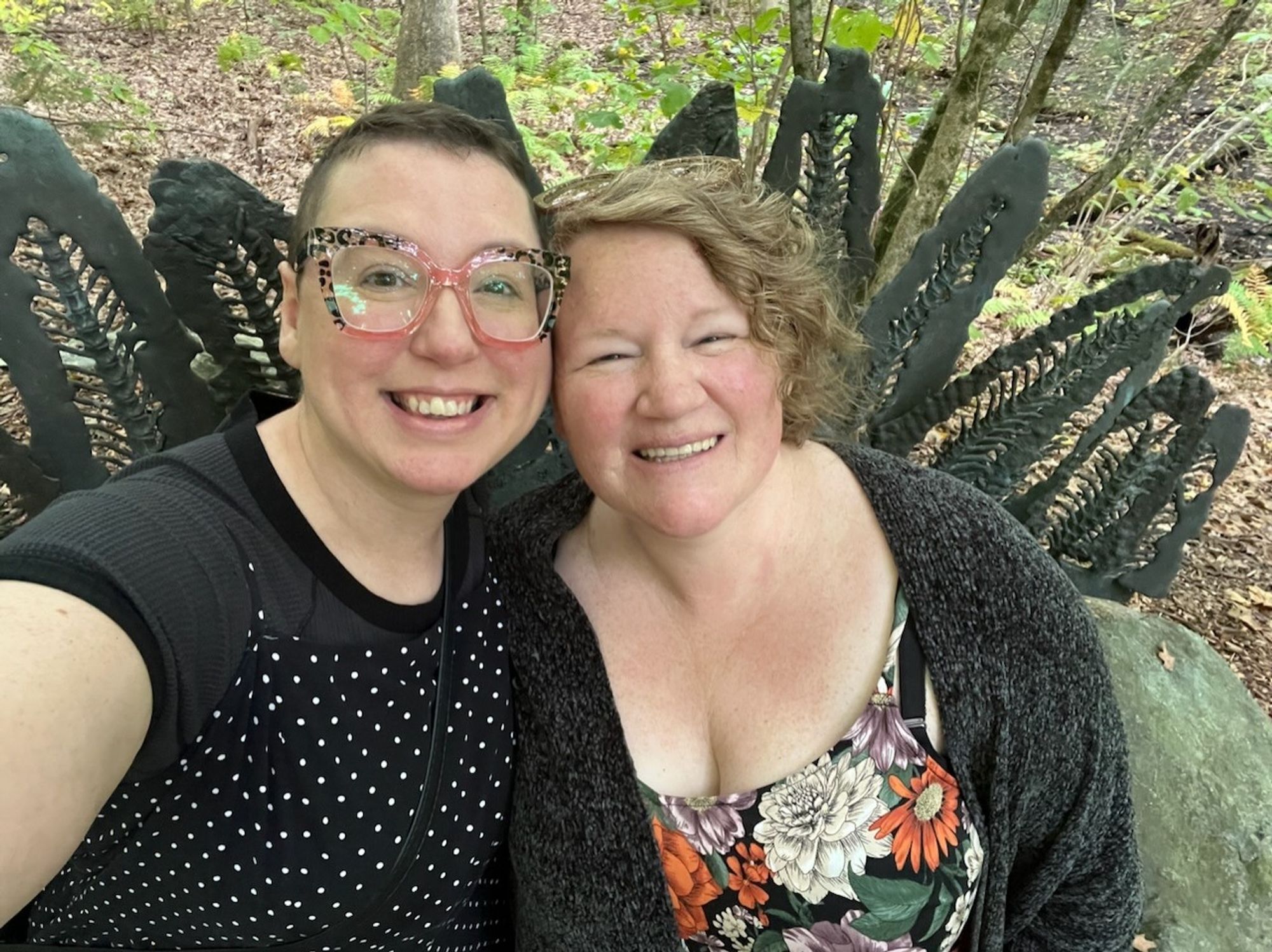 A photo of Liz and I leaning against the rock sculpture. The metal spikes are splayed out behind us.