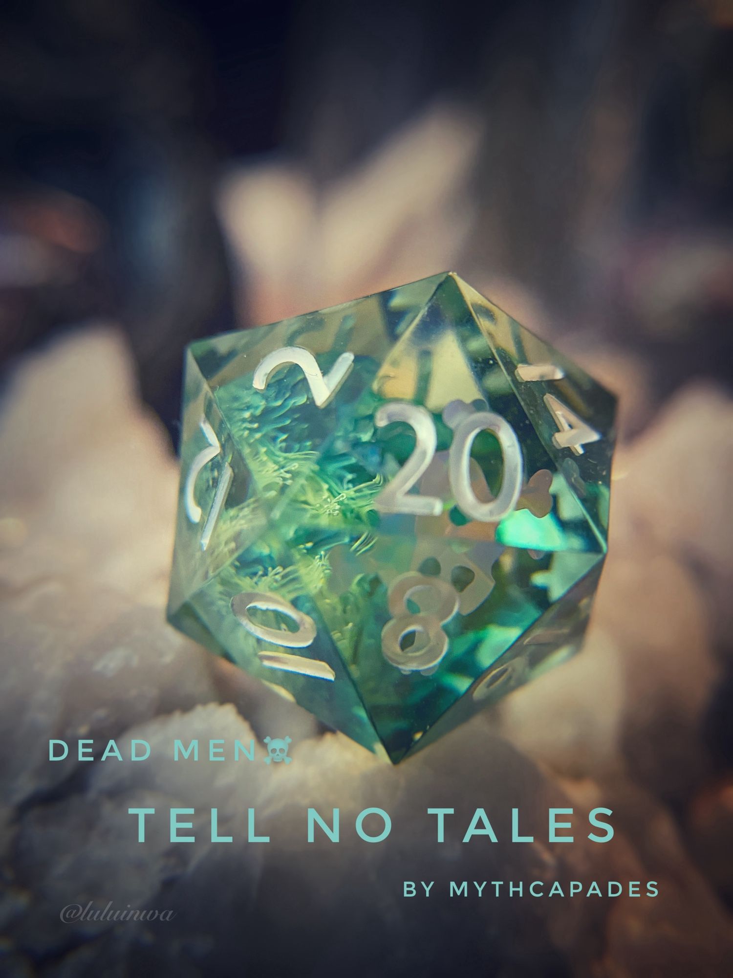 Sea green clear d20 with silver skull and crossbones inside