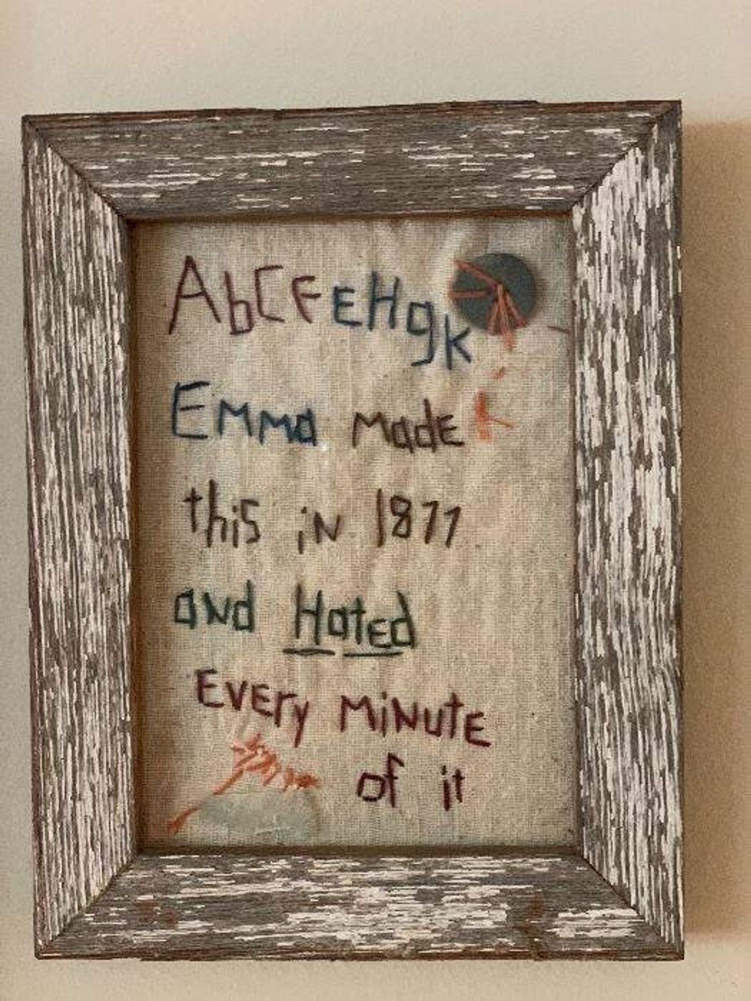 Emma's embroidery sampler from 1877. It reads "A b C F E H g K EMMa MadE thiS iN 1877 aNd HatEd (underlined) EvEry MiNute of it" the emphasis on capital and lower case letters is made to show that Emma chose between the two that would use less stitches and allow her to fill up her "canvas"  faster.