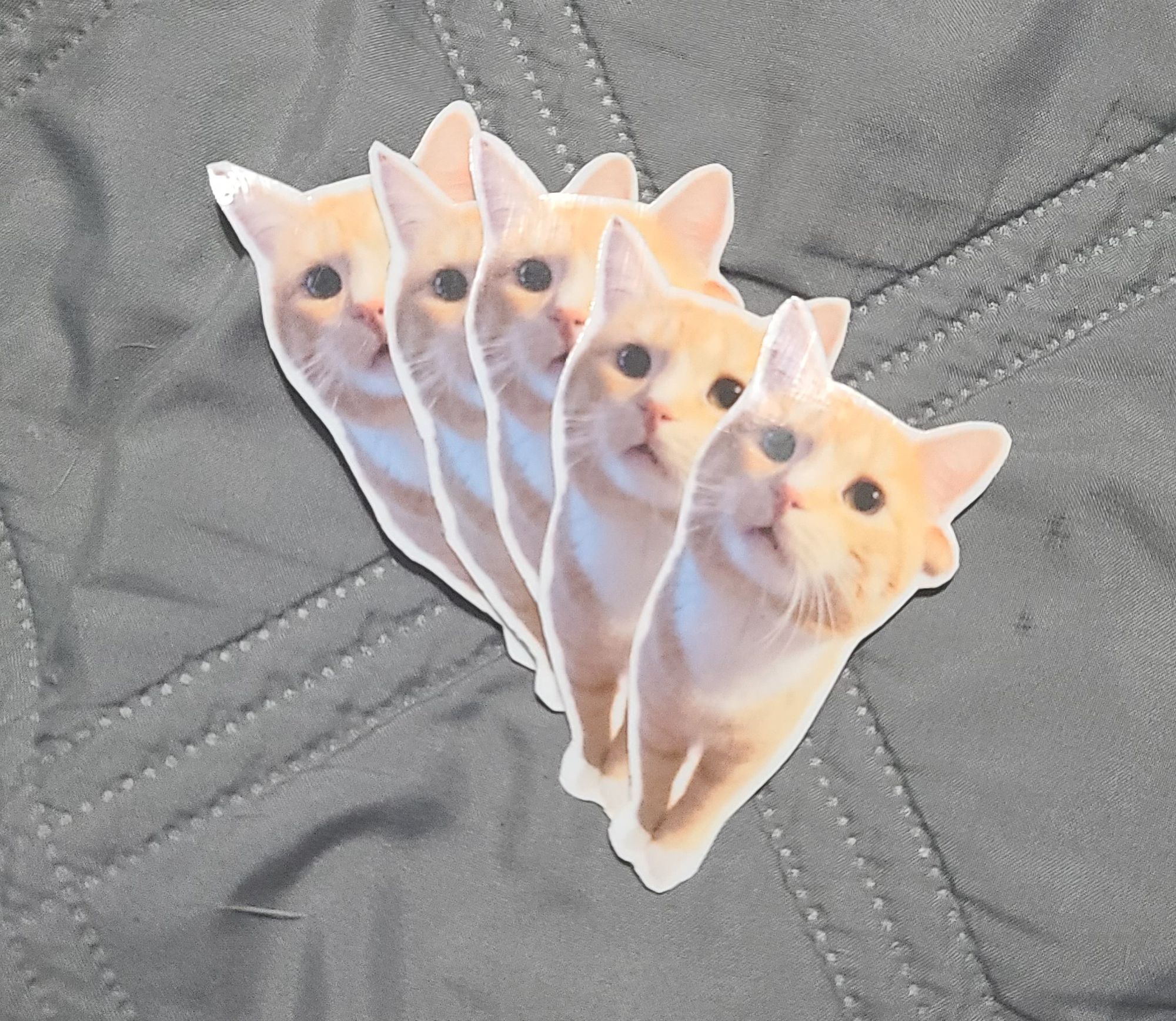 a fanned-out stack of vinyl sticker of my orange cat chewie