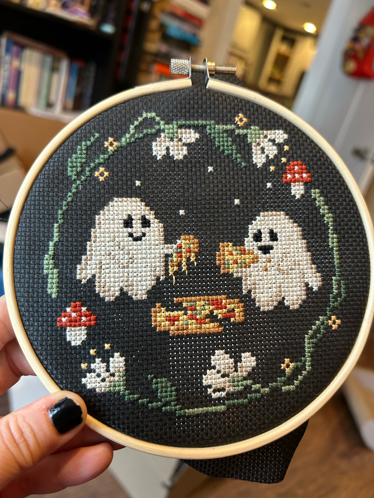 Small cross stitch of cute ghosts eating pizza on black 14-count cloth