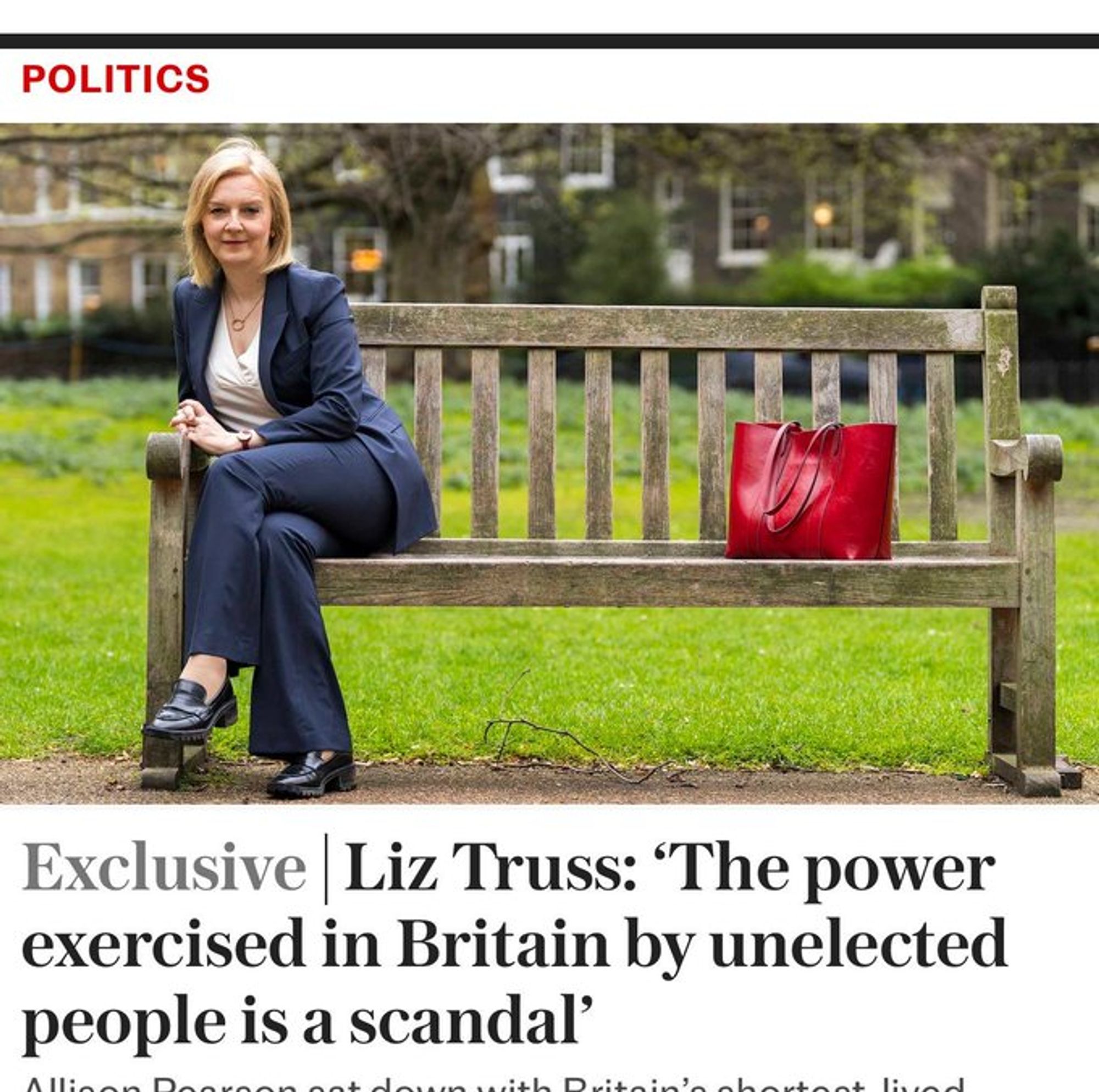 Liz Truss sitting on a bench as far away as she can get from a big red handbag. Her entire body language says 'I'm not speaking to it until it apologises.'