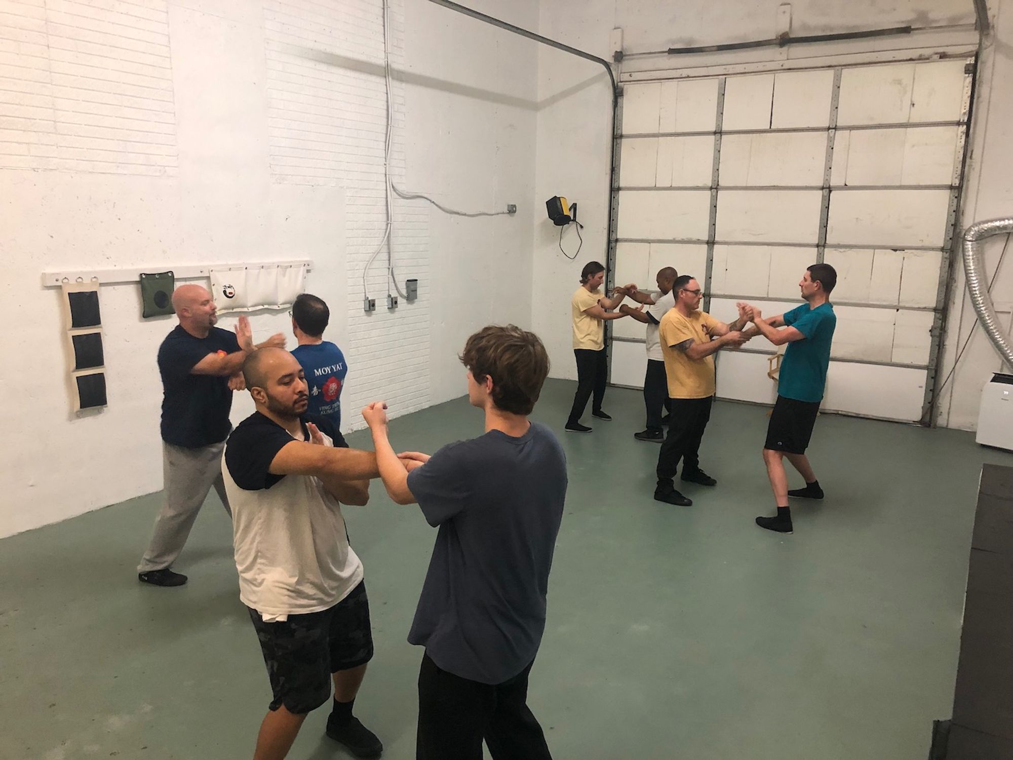 At the Kung Fu Fxbg warehouse school in August 2024, four pairs of men are facing each other while doing various 'Chi Sao' ('sticking hands' or 'energy hands') exercises in the Ving Tsun (wing chun) Kung Fu system of martial arts training for health, fitness and self defense.