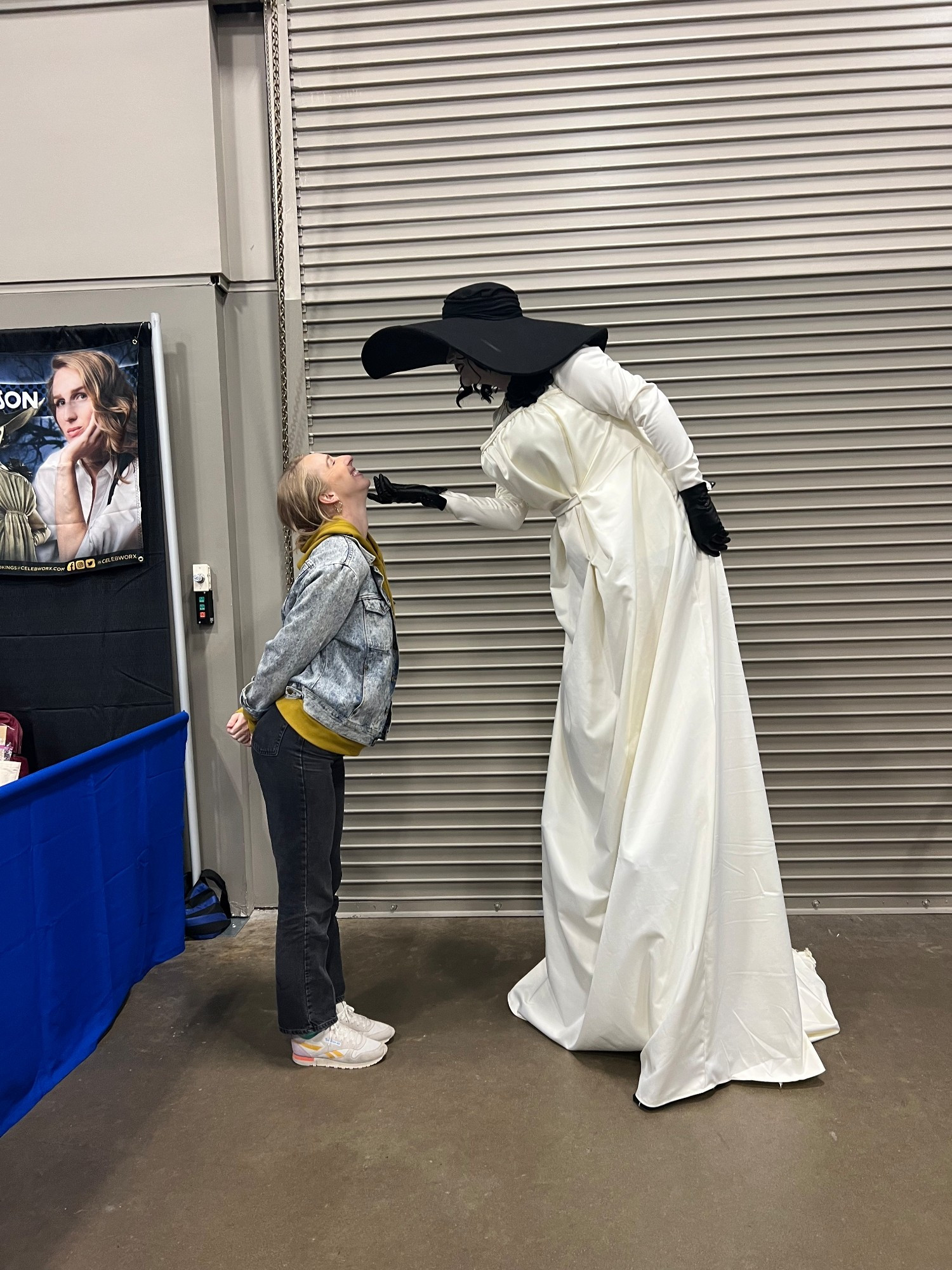 CosplayMeg in her Lady Dimitrescu cosplay posing while tilting Maggie Robertson's chin up to look at her