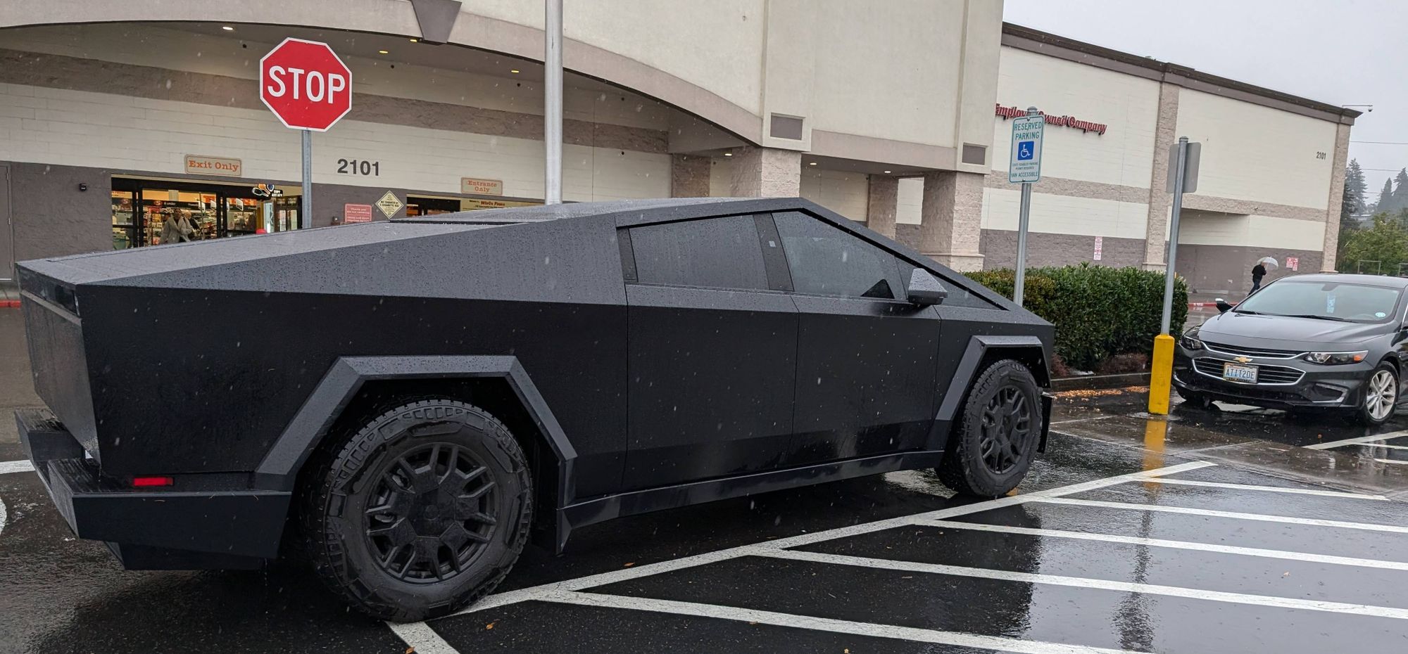 A matte black cybertruck with dark tinted windows and black hubcaps. It looks incredibly stupid and ugly. Who decided to pay an obscene amount of money for this car straight out of an 8 year old's sketch book? We may never know.