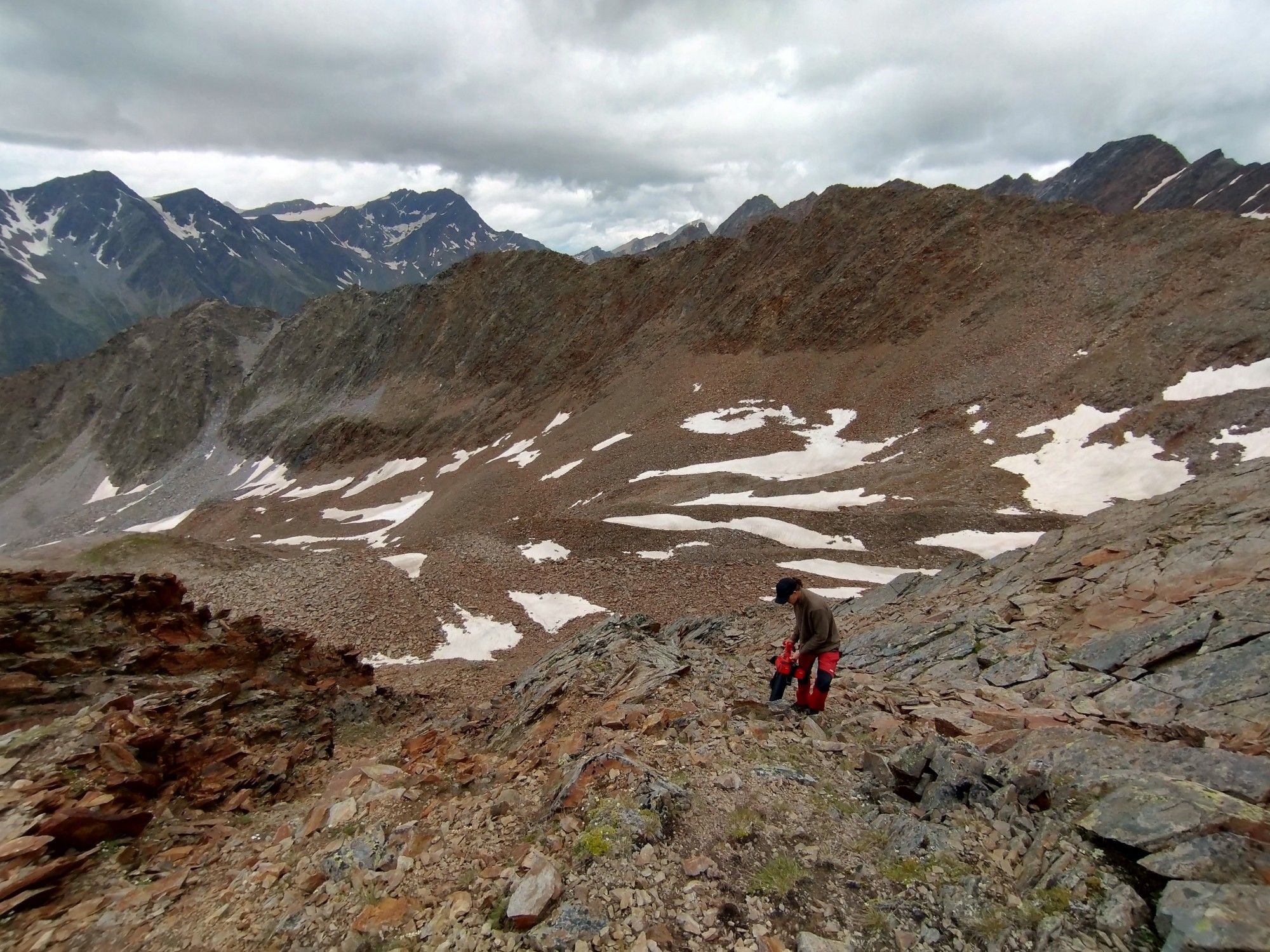 A biologist taking suction samples with a modified leaf vacuum at a 3100m mountain peak.