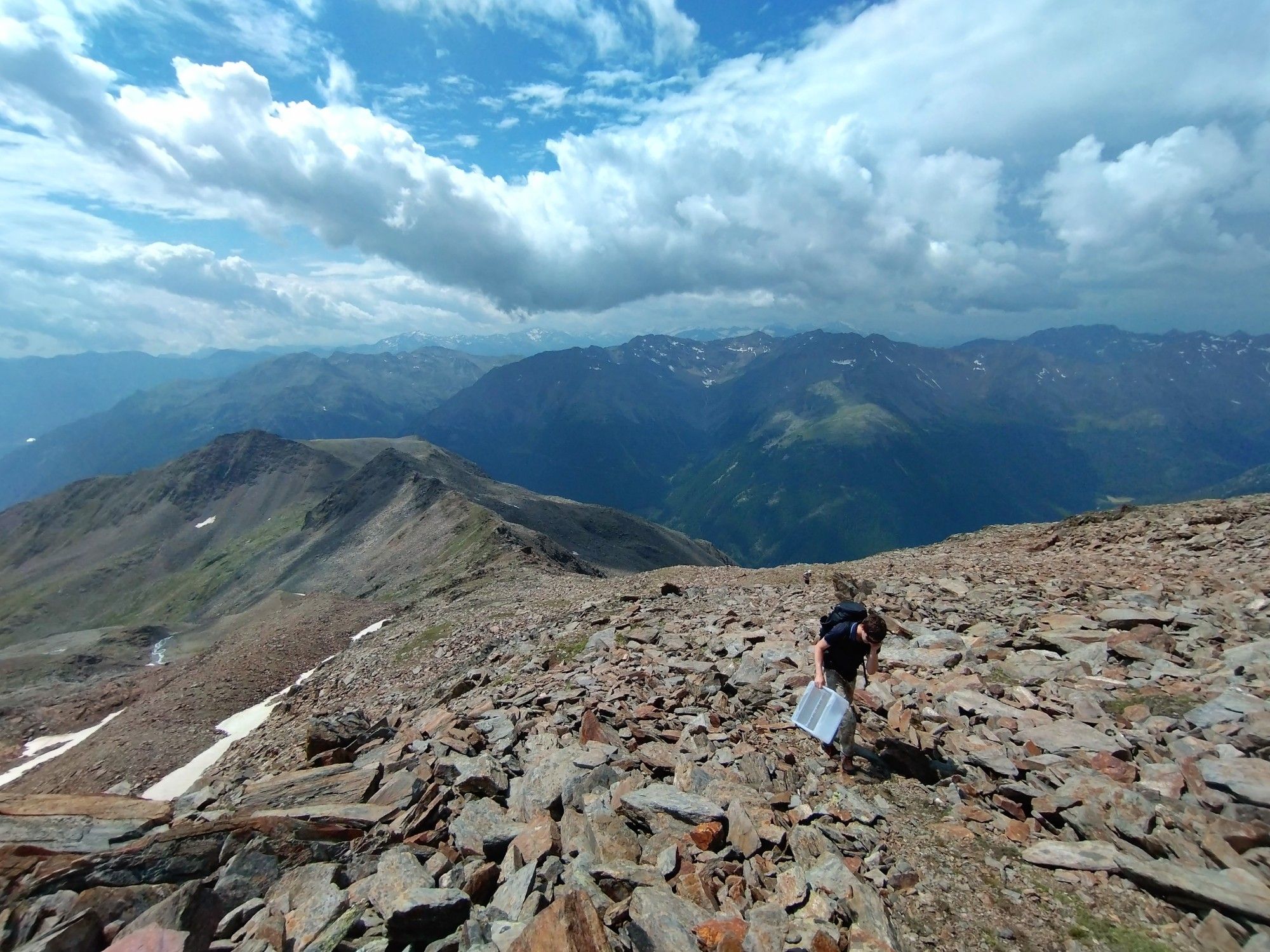 Pocture showing soil ecologists climving up a high alpine mountain to investigate soil fauna.