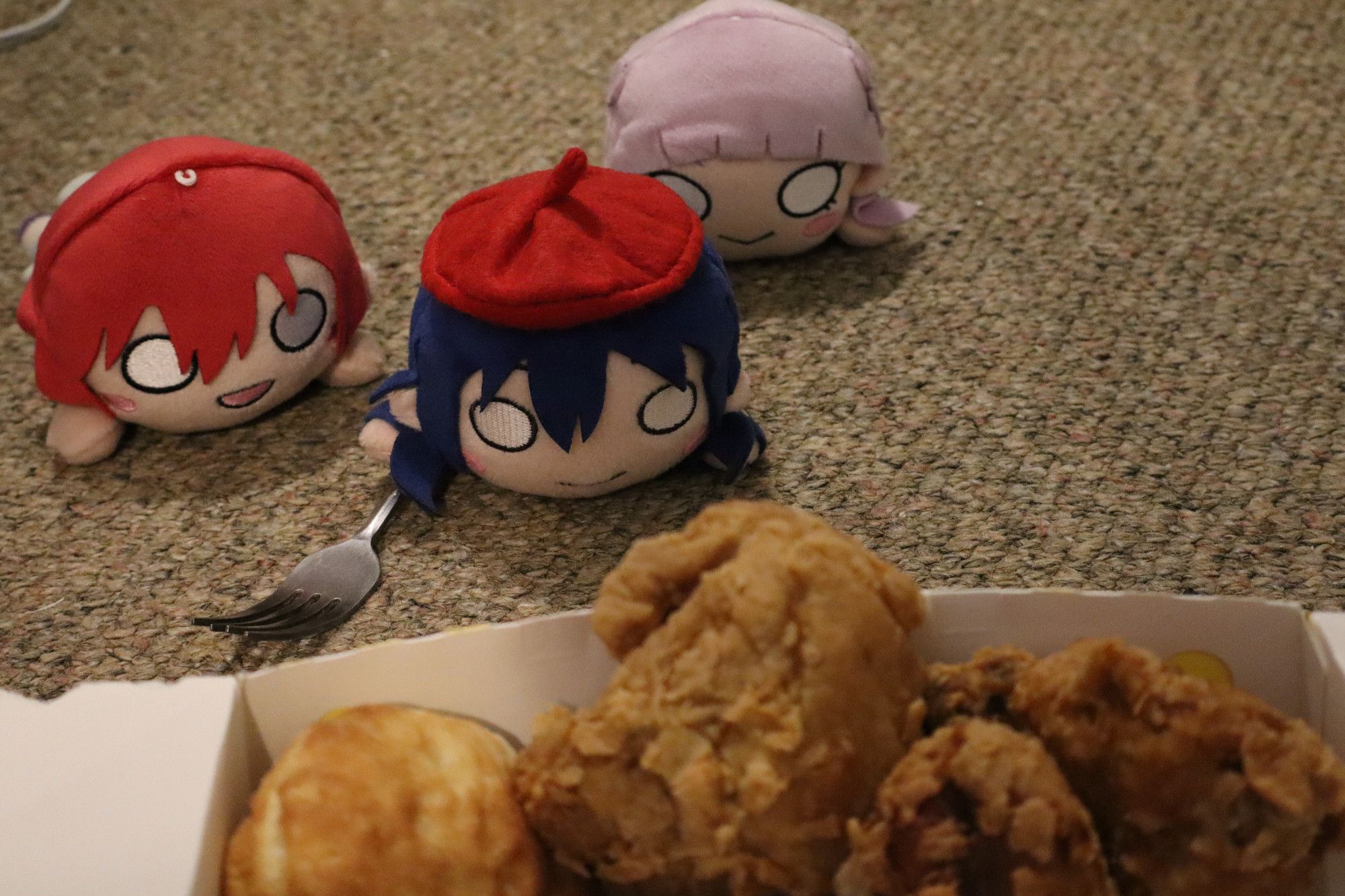 Umi, Emma, and Margarete approach a box of fried chicken.