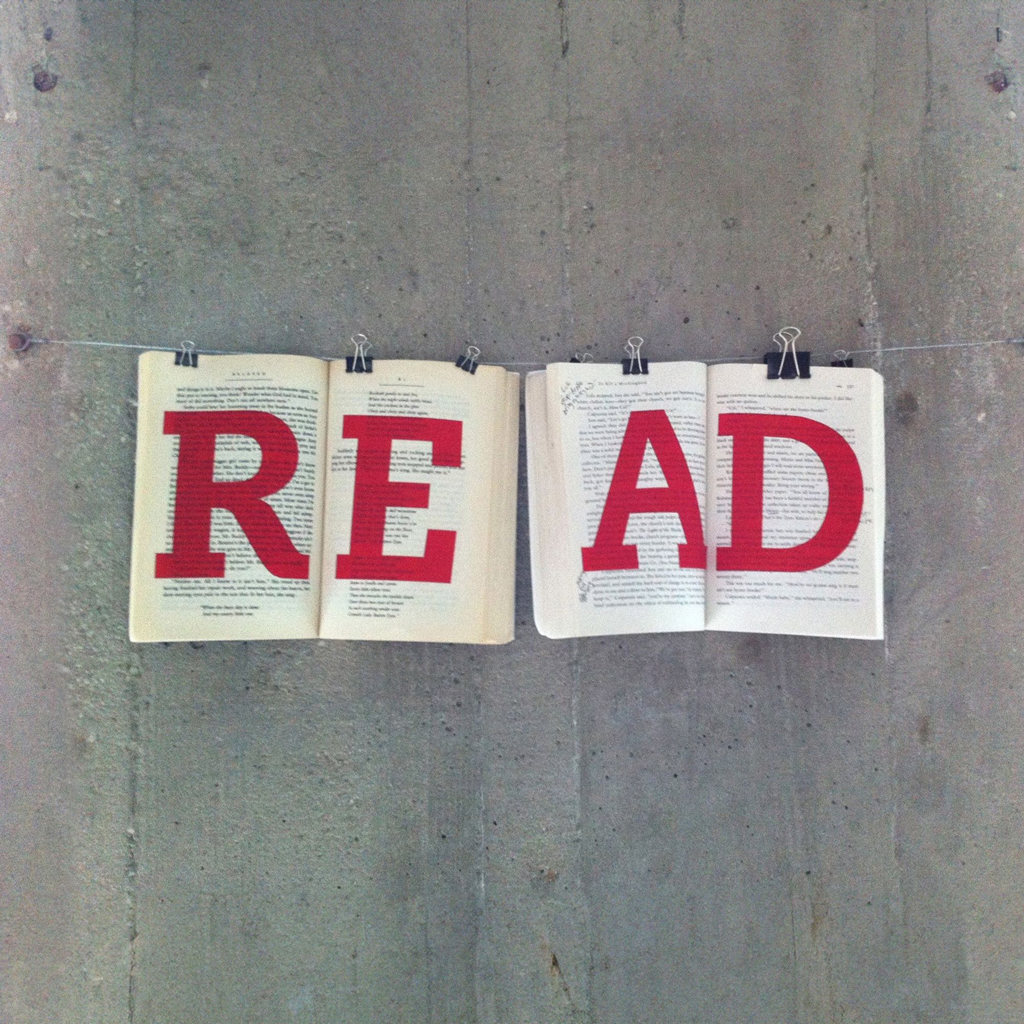 Photograph of two open books hung on a wire, with scarlet letters spelling READ. Once the campaign photos were taken (this one for a button/badge that said "Celebrate the freedom to read"), they became wall art in my office.