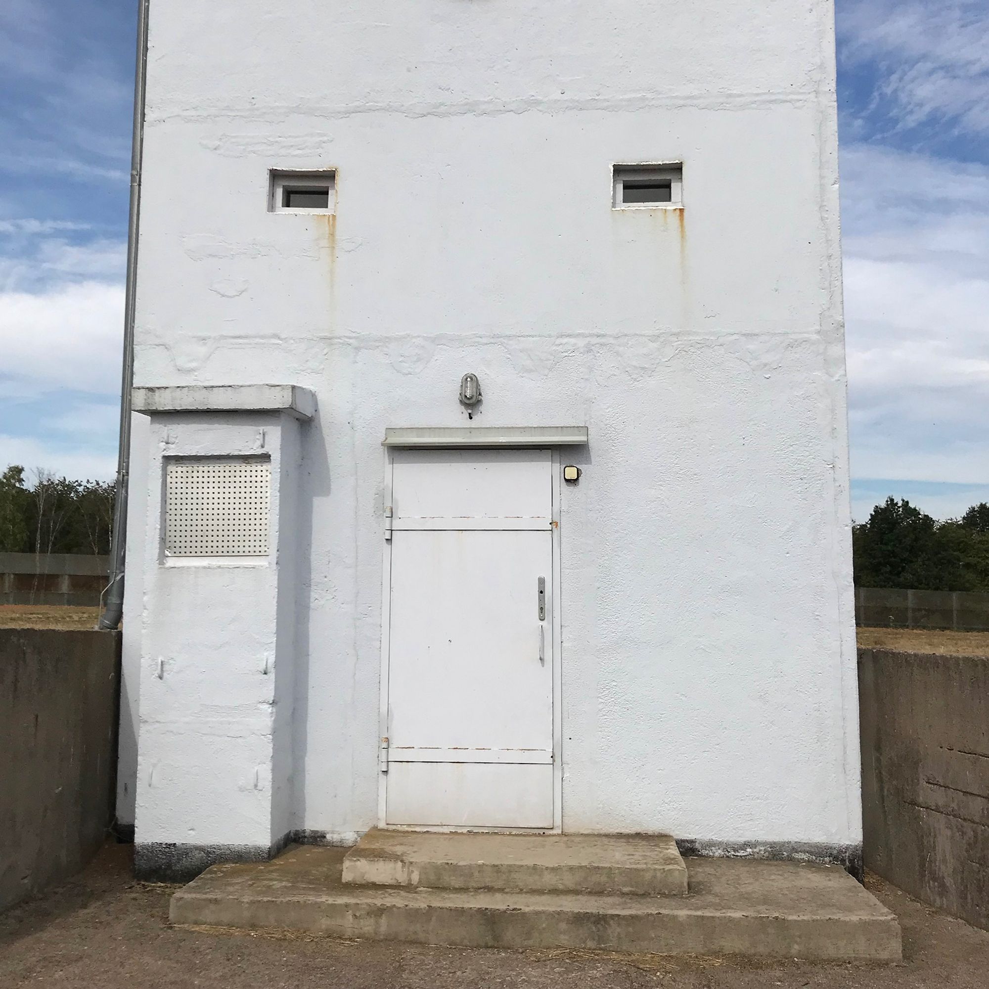 A watchtower on the former border between the GDR and the FRG, Teistungen, Germany. There is a suggestion of pareidolia, i.e.: seeing faces in inanimate objects, where rust stains in the corner of the windows seem like tears. 

Photo by Gearóid Burke, all rights reserved. 