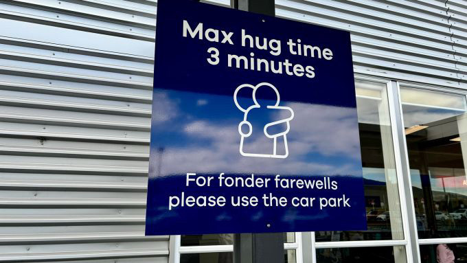 Sign at New Zealand airport that says “maximum hug time 3 minutes, for fonder farewells please use the car park”