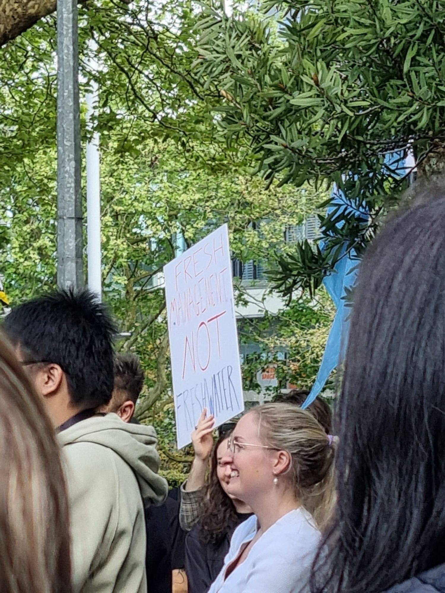 Person holding a sign saying 
FRESH MANAGEMENT NOT FRESHWATER