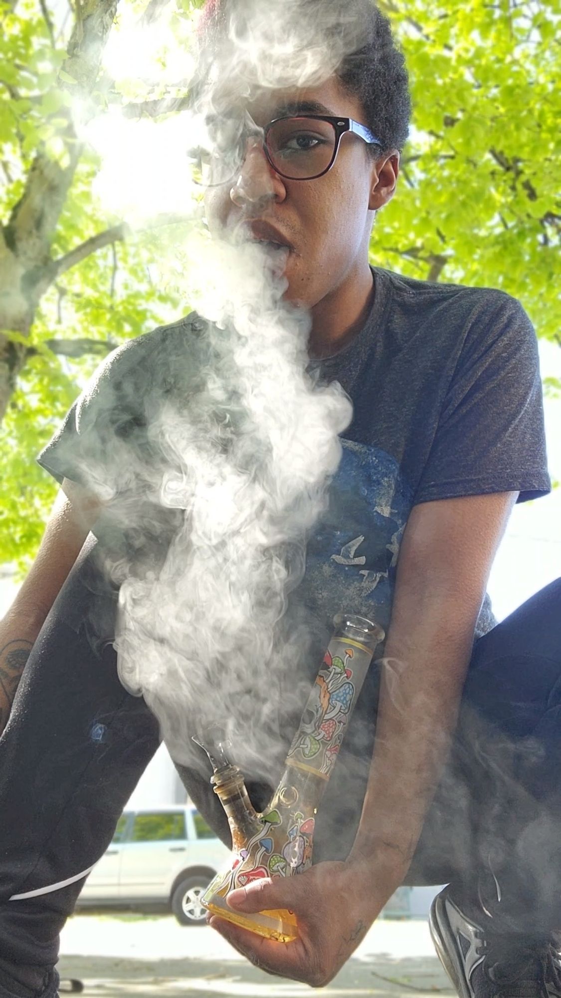 Indigo exhaling a fat bong rip outside.