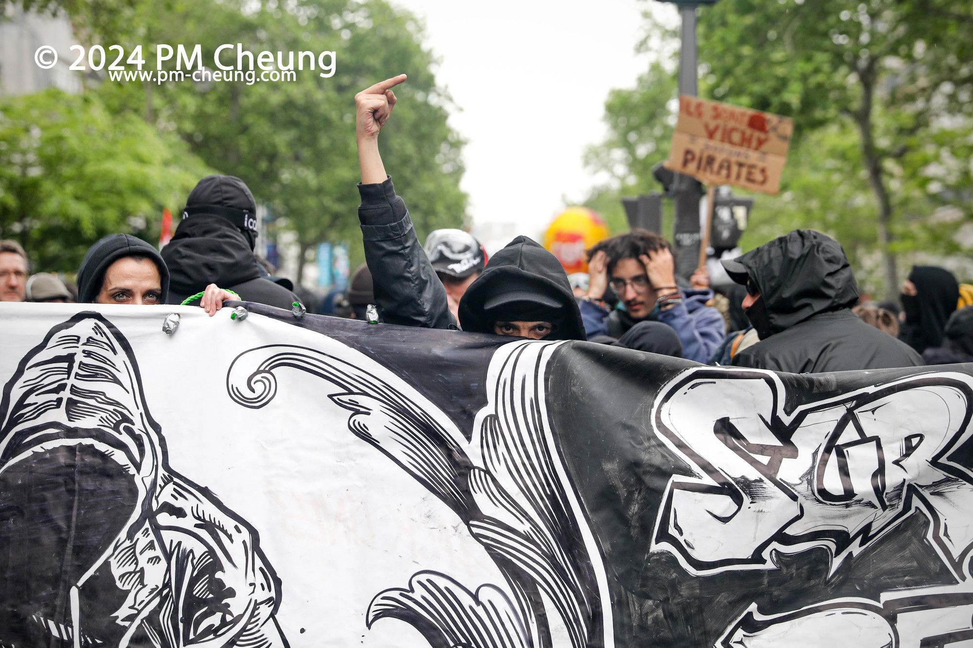 Auf der Boulevard du Temple regt ein schwarzgekleideter Demonstrant seinen Mittelfinger in die Höhe.