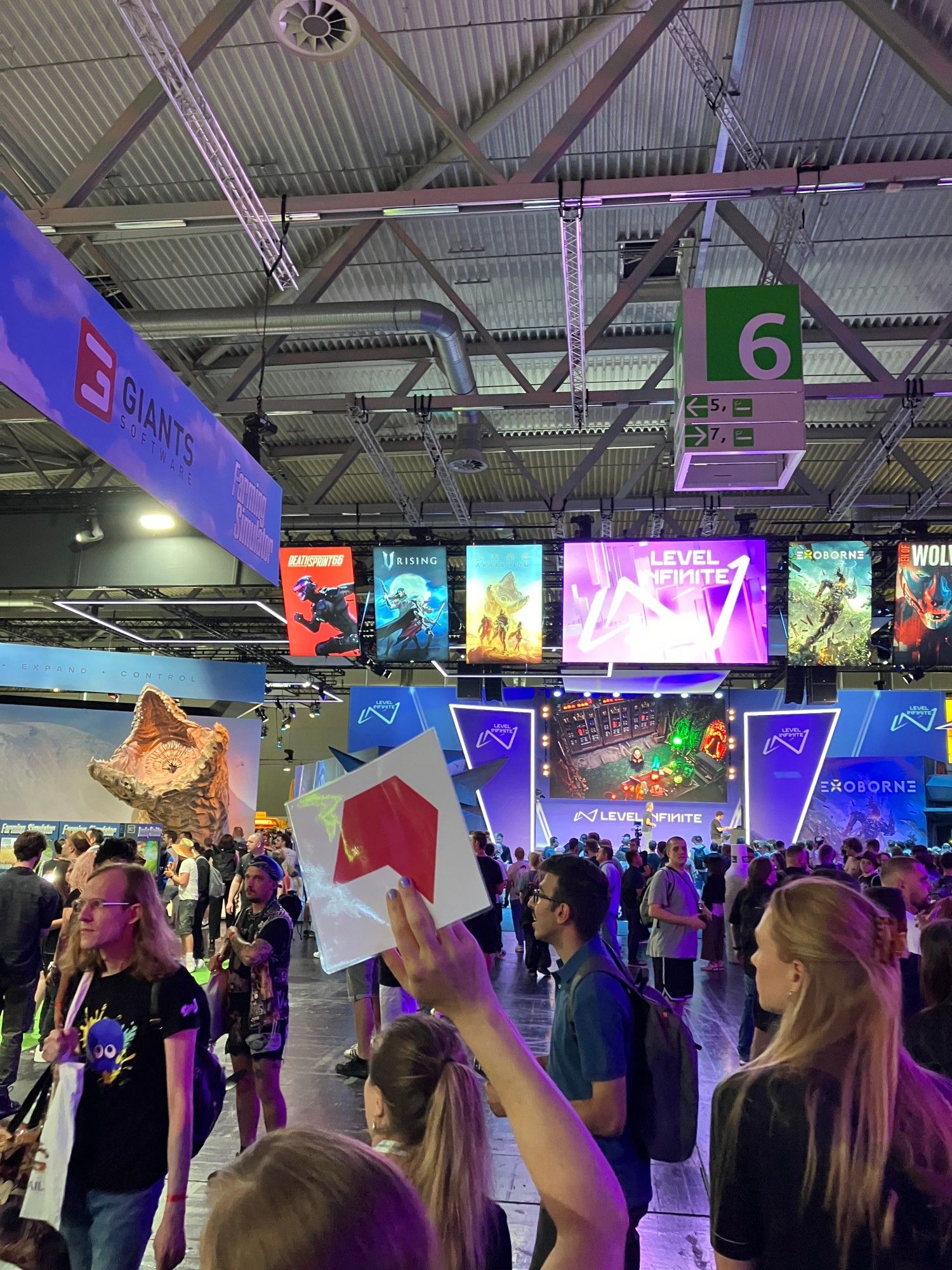 Ein Bild aus der Halle 6 auf der Gamescom. Im Vordergrund der Menschenmenge wird das Logo des Börsenvereins hochgehalten.