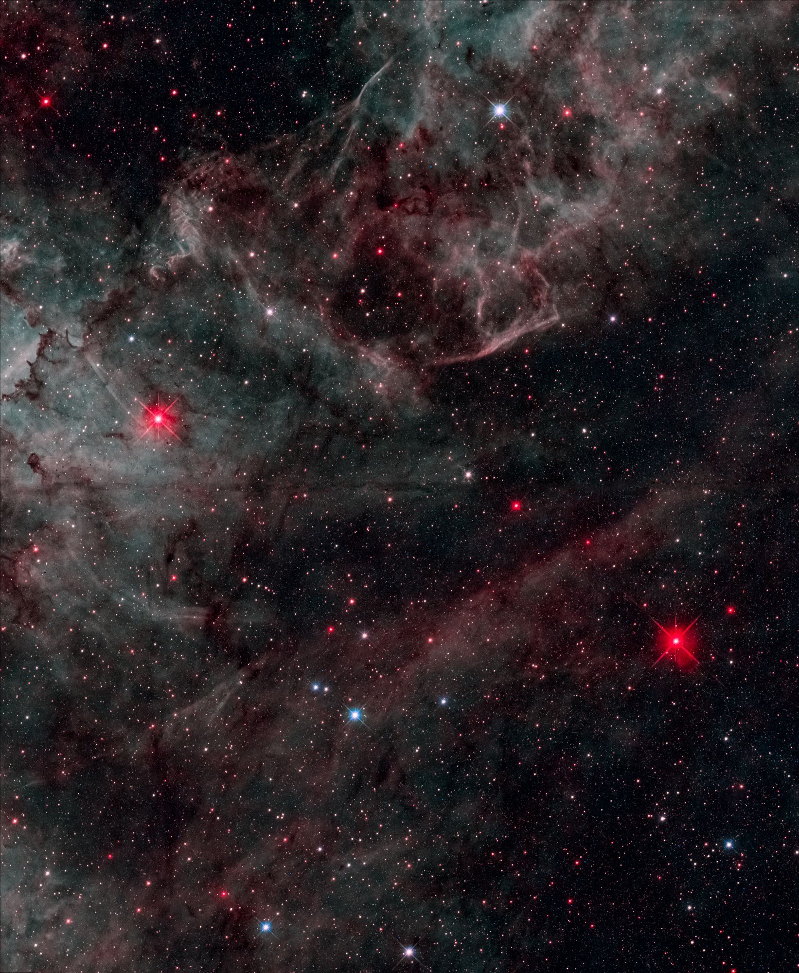 A large gas cloud, with no particular form, occupying the whole image. This cloud is giving cyan, green and red colors, with some spikes in the cloud: pillars where new stars are born! A lot of stars can also be seen in the background.