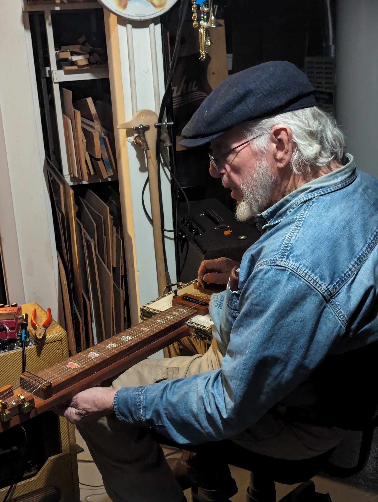 Old man playing lap steel guitar.