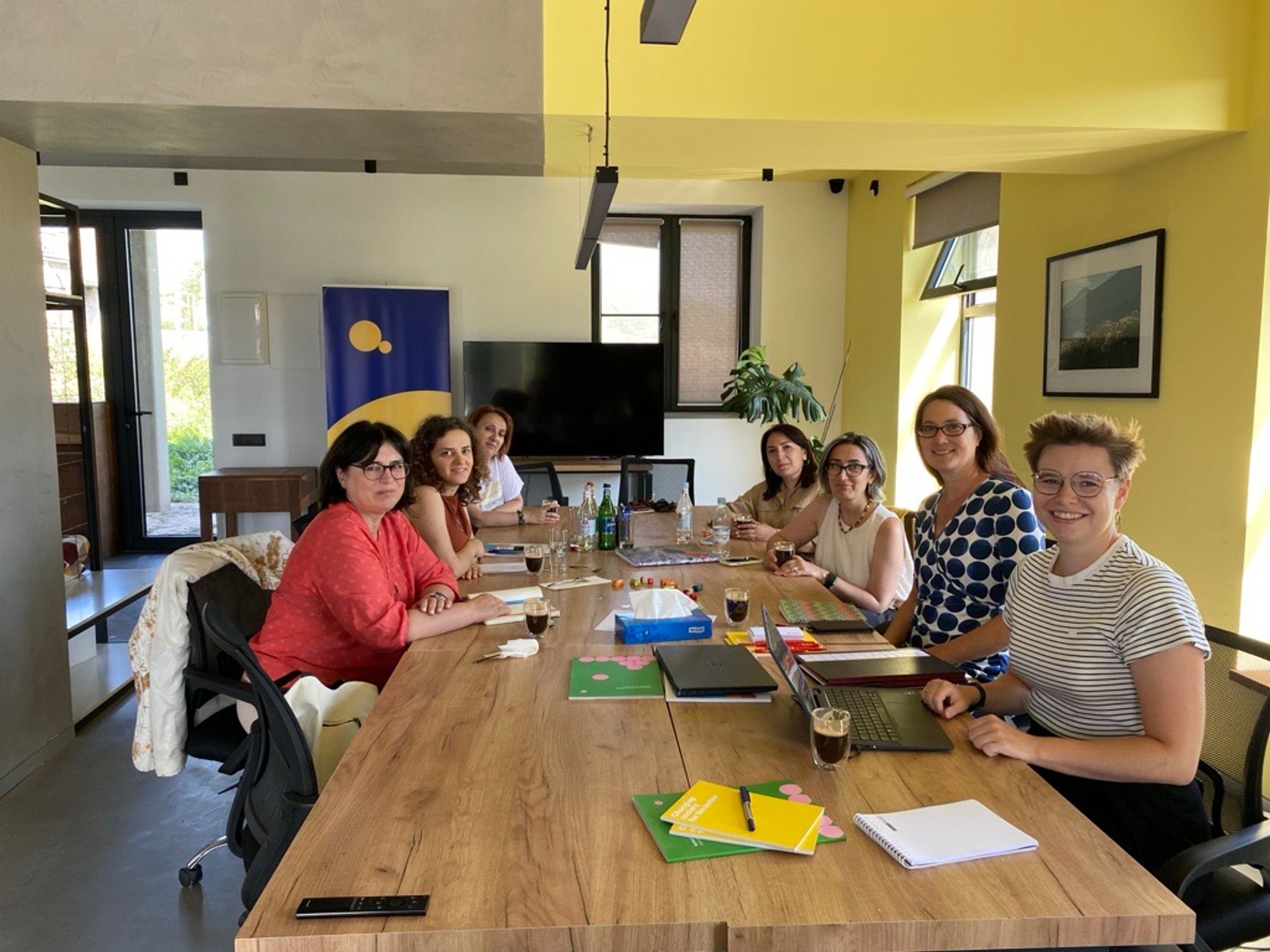 7 persons sitting at a wooden office table