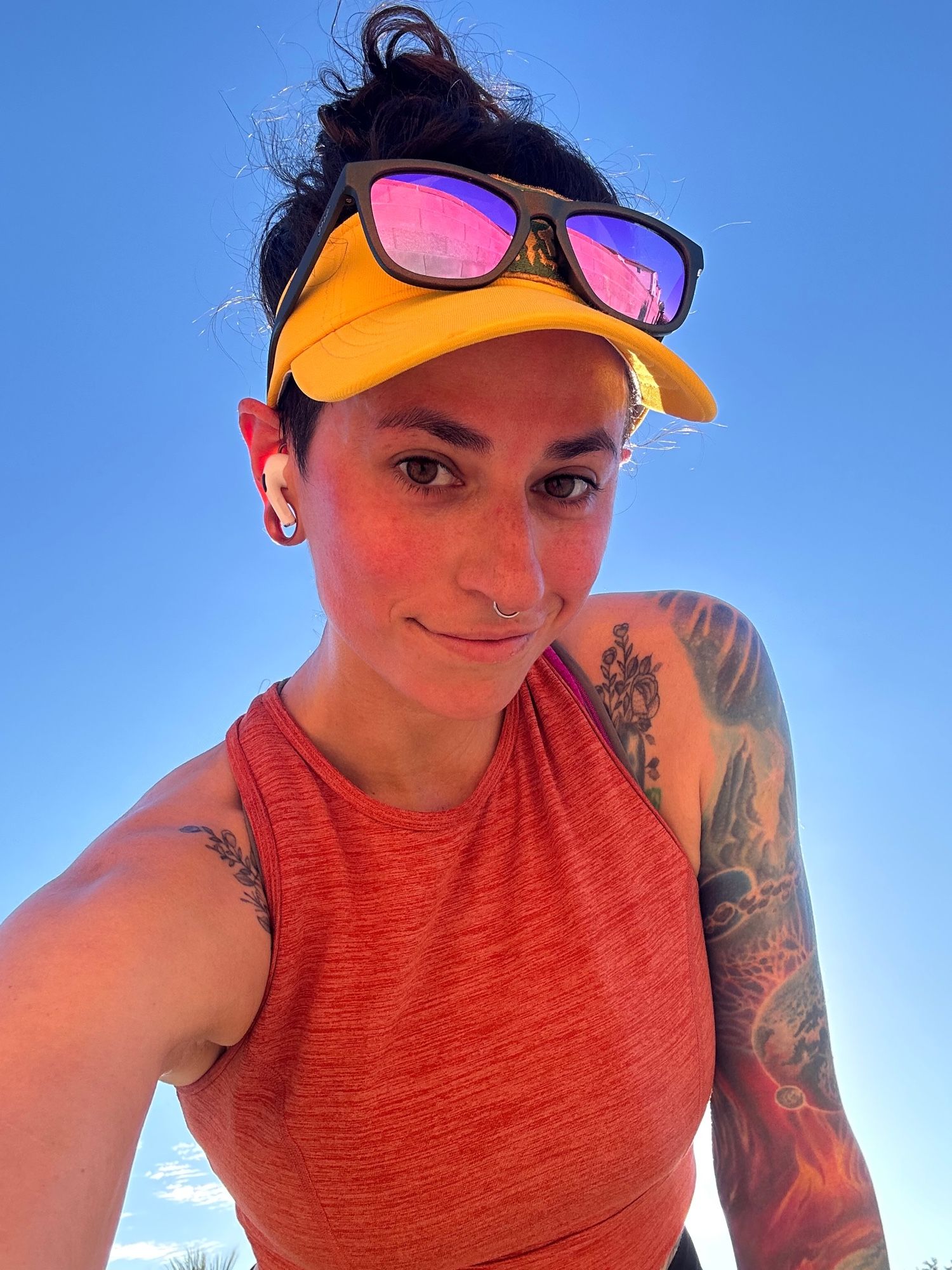 Selfie of Annika in running clothes and sunglasses, backlit against a bluesky