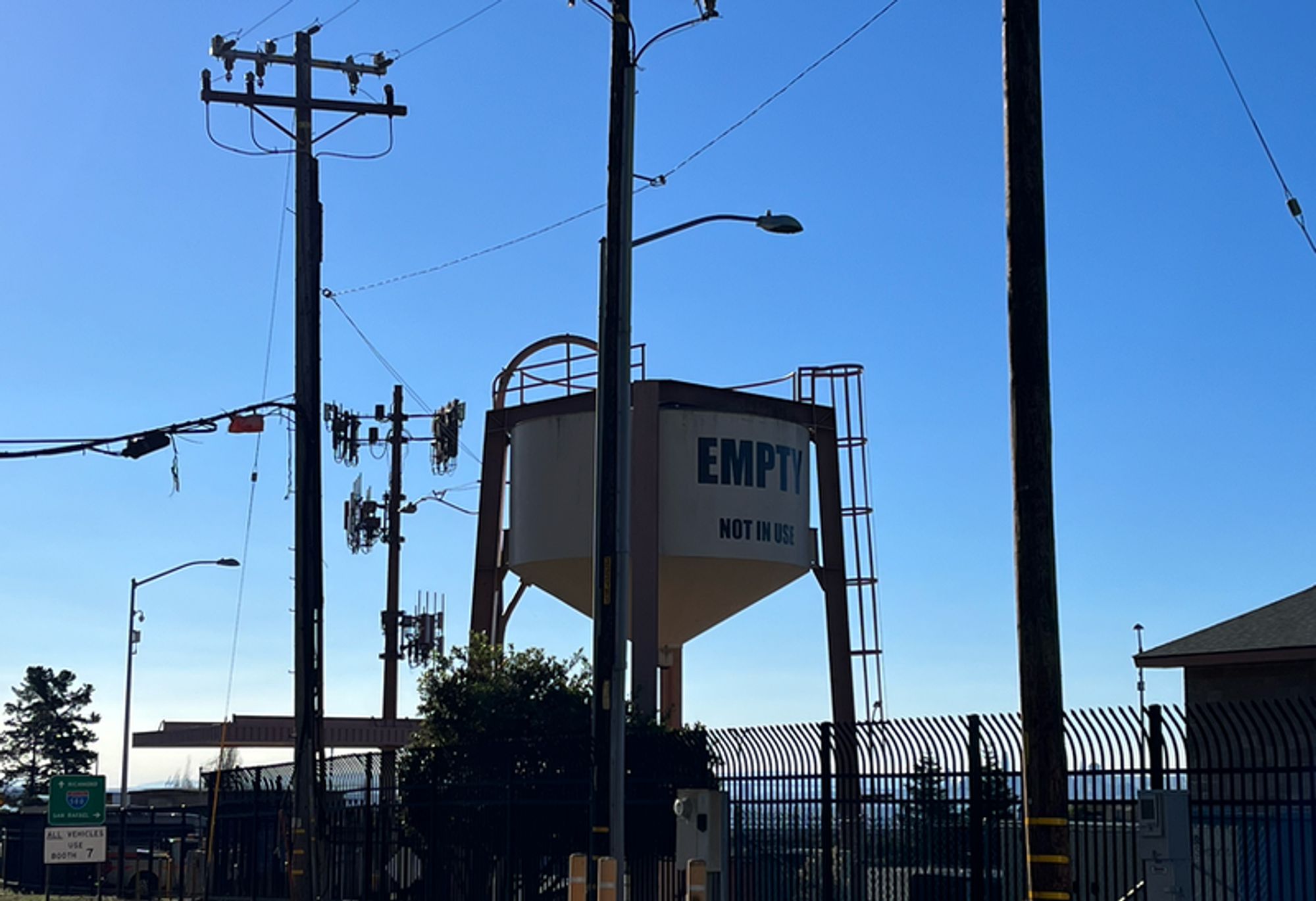 A small water tower, against a blue sky, with the label, "EMPTY"