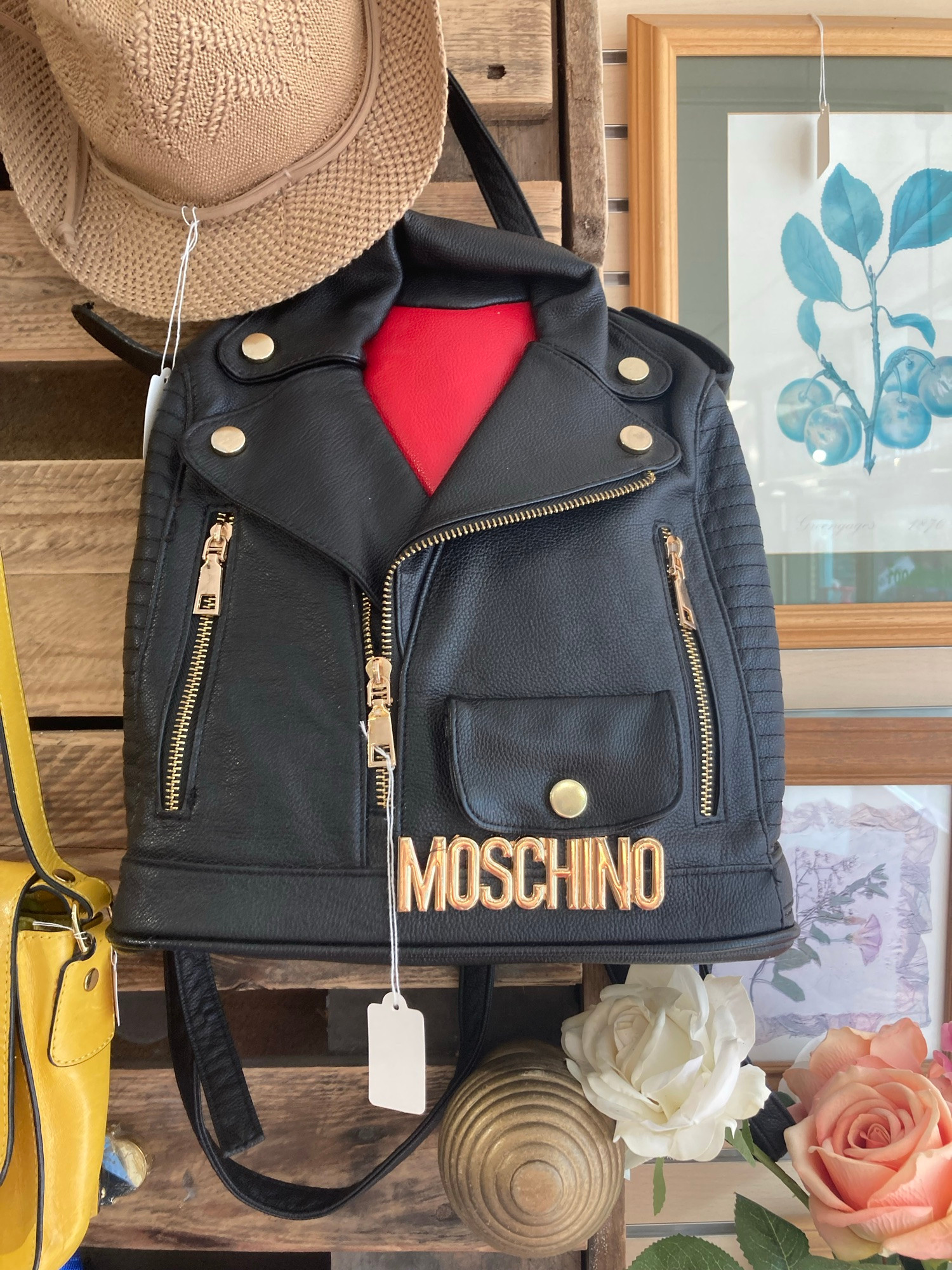 A bag hanging on a display wall in a shop. It’s designed to look like a leather jacket.