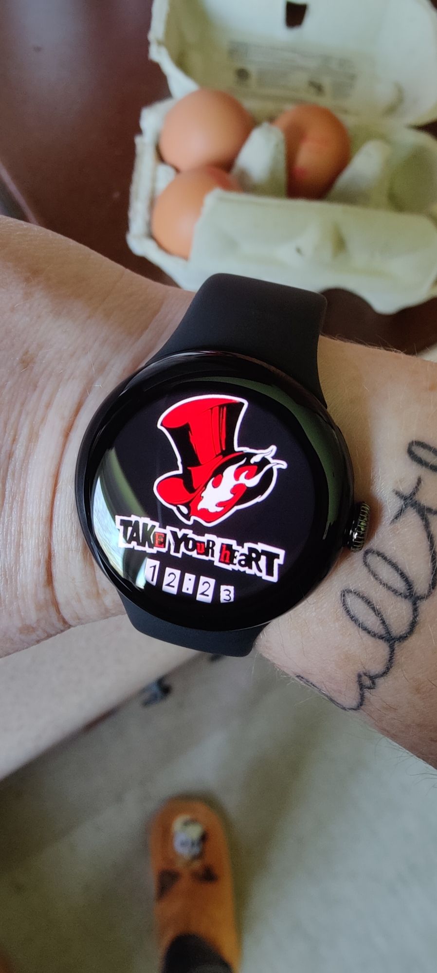 Pixel Watch 2 with a Persona 5 themed face showing the words 'Take Your Heart' and the time.