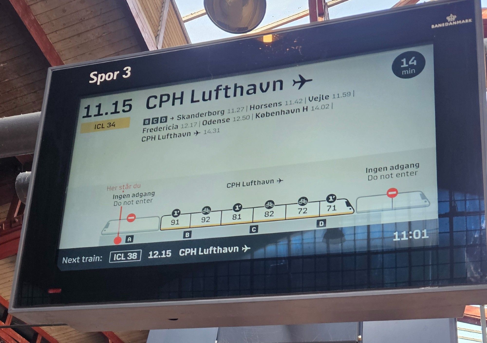 An image of a train departure screen, taken at Aarhus H station. The screen shows a visualization of a train, where the screen currently is on the platform, relative to the train and where you should ideally be for your carriage and seat