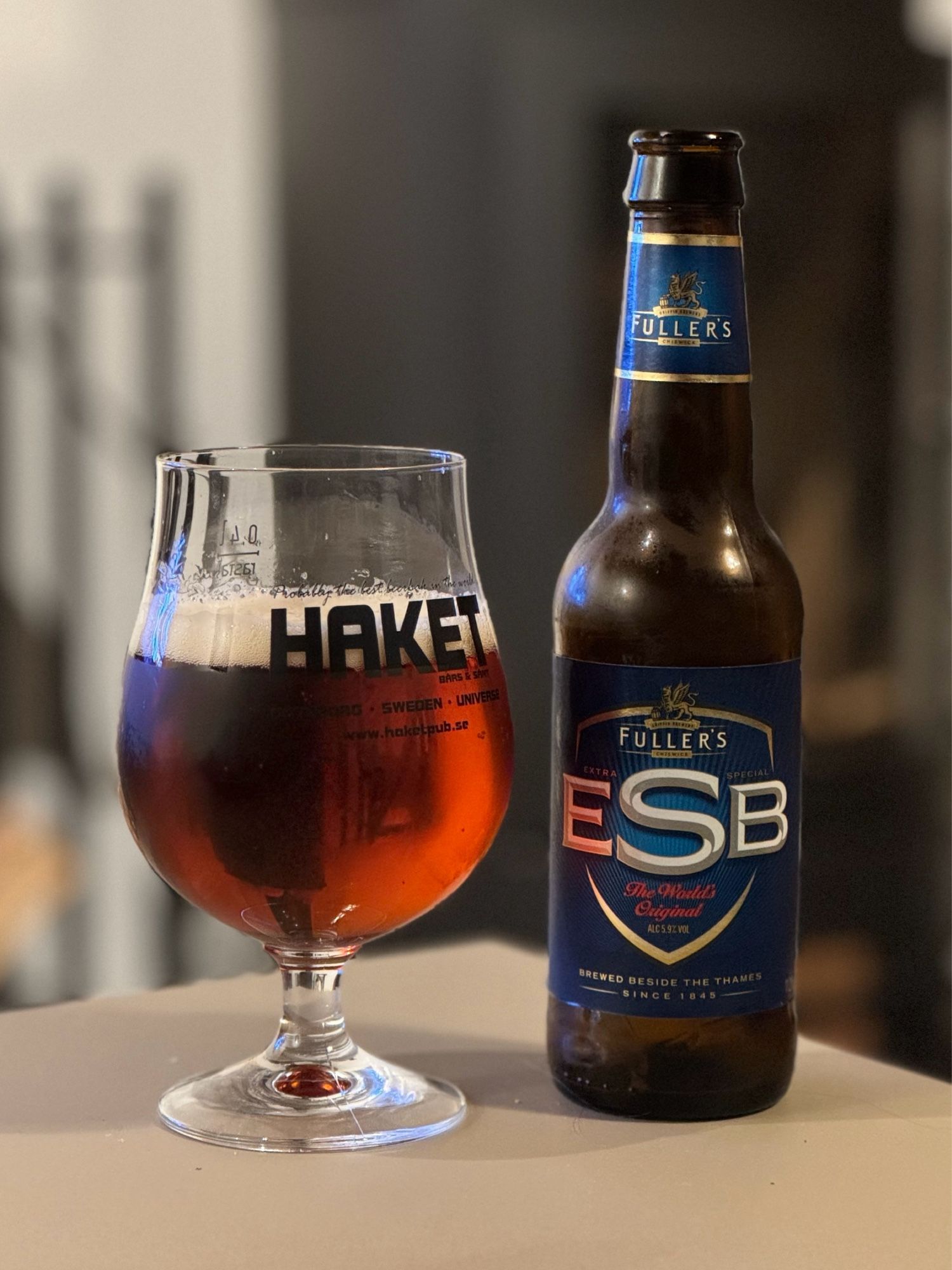 En flaska Fuller's ESB upphälld I ett ölglas från Haket