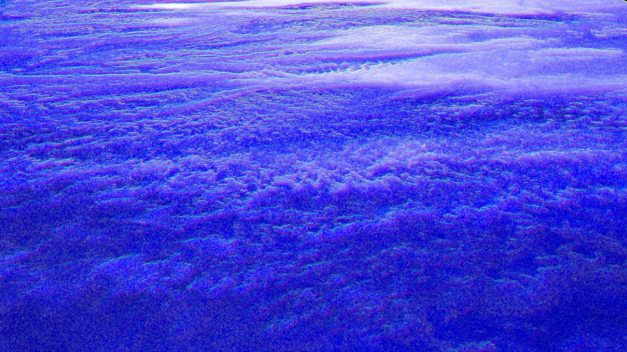 A shot of what appears to be a sapphire ocean with heavy waves and a light coming down from the top of the frame. Created by generating a normal map of a sunset and blending the map to the base photograph.