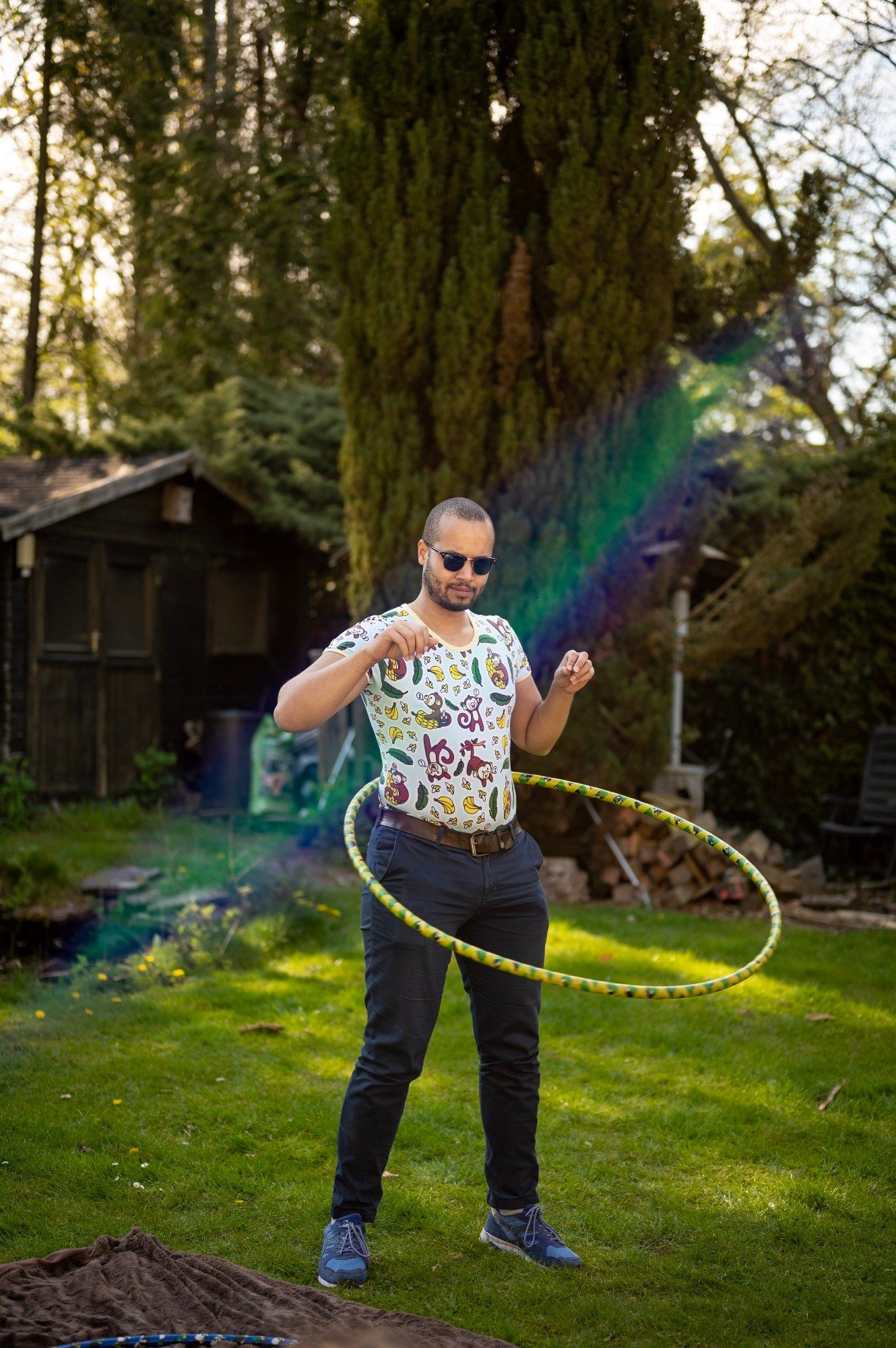 Guy with hoolahoop and onesie and diaper under jeans