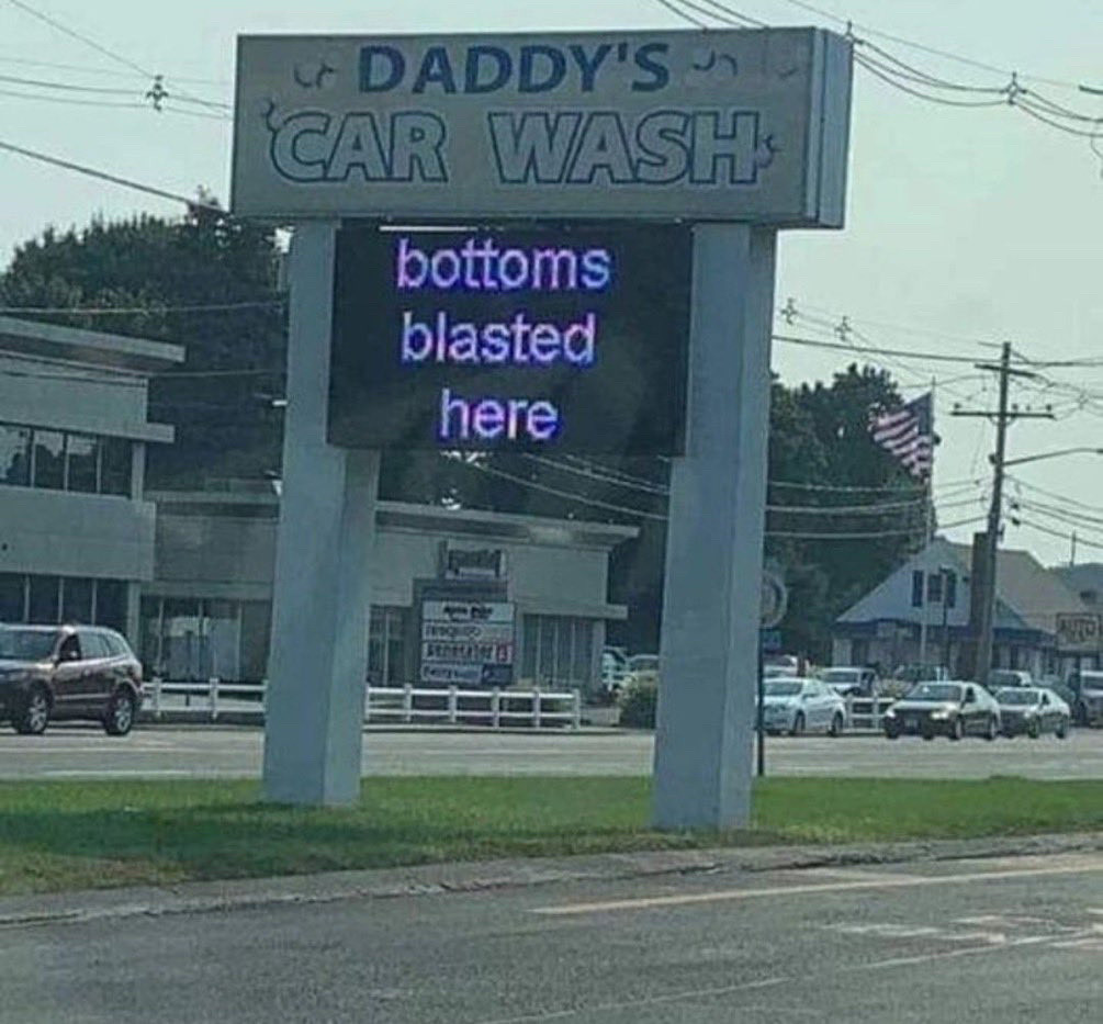 A sign for Daddy’s Car Wash saying “bottoms blasted here”