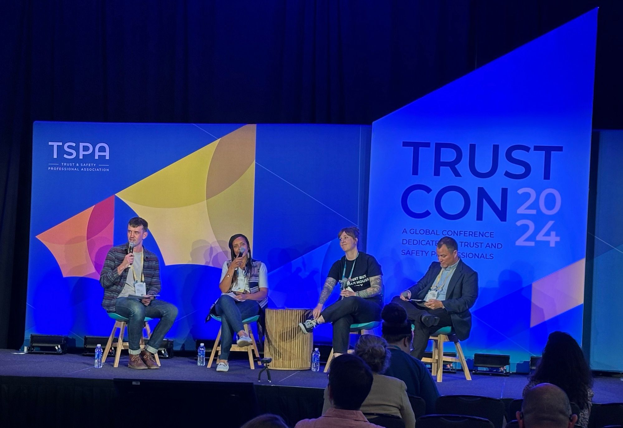 Stage at TrustCon for live podcast recording with four speakers