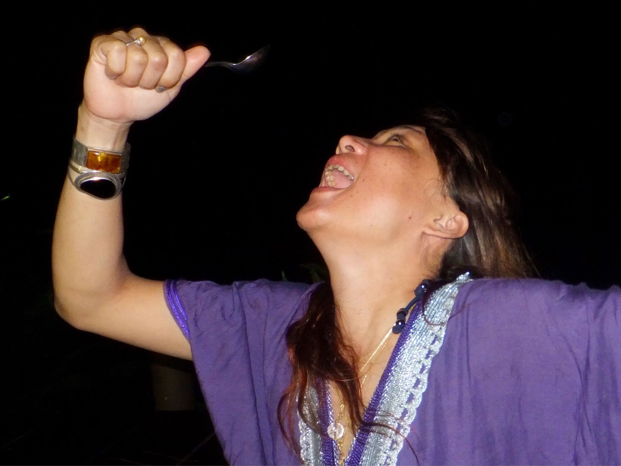 A girl singing and using a spoon as a microphone