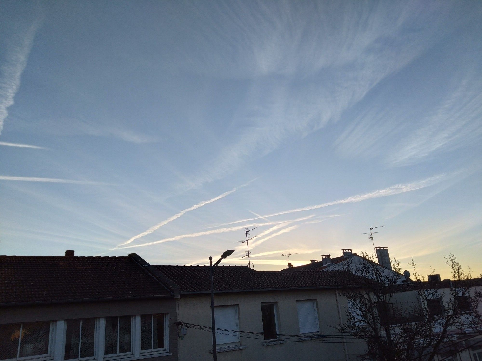 Ciel avec traînées de condensation au moment du lever de soleil