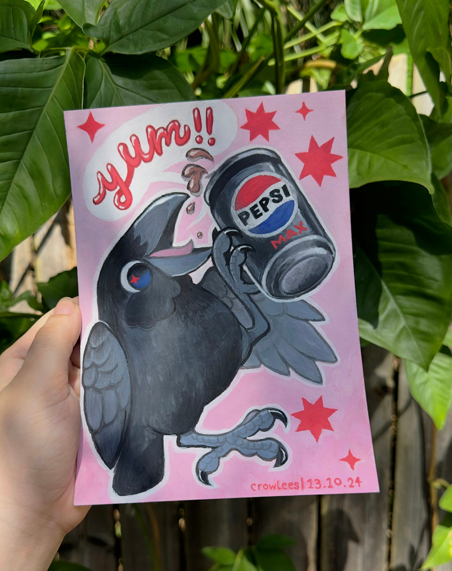 An A5 sized gouache painting of a cute lil crow holding a pepsi max can - some of it is spilling out from the top. A white text bubble has the word "yum!!" in red bubble lettering. The crow is on a soft pink background, decorated with red stars.